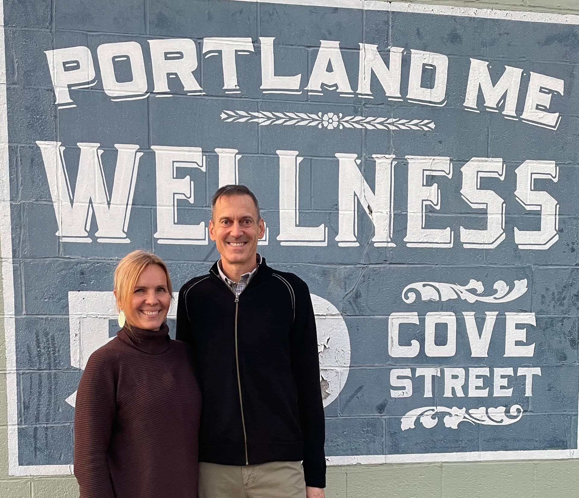 a room with a chair, shelf, and a poster on the wall