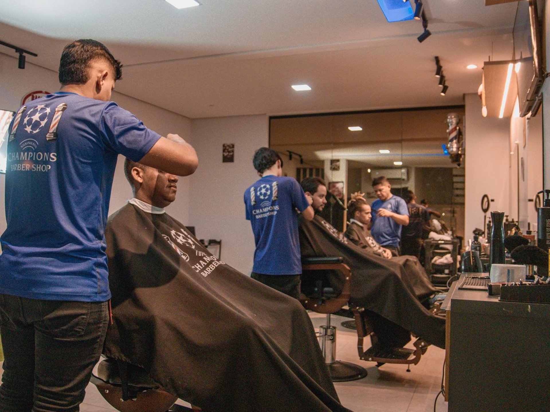 a man cutting another mans hair with a pair of scissors