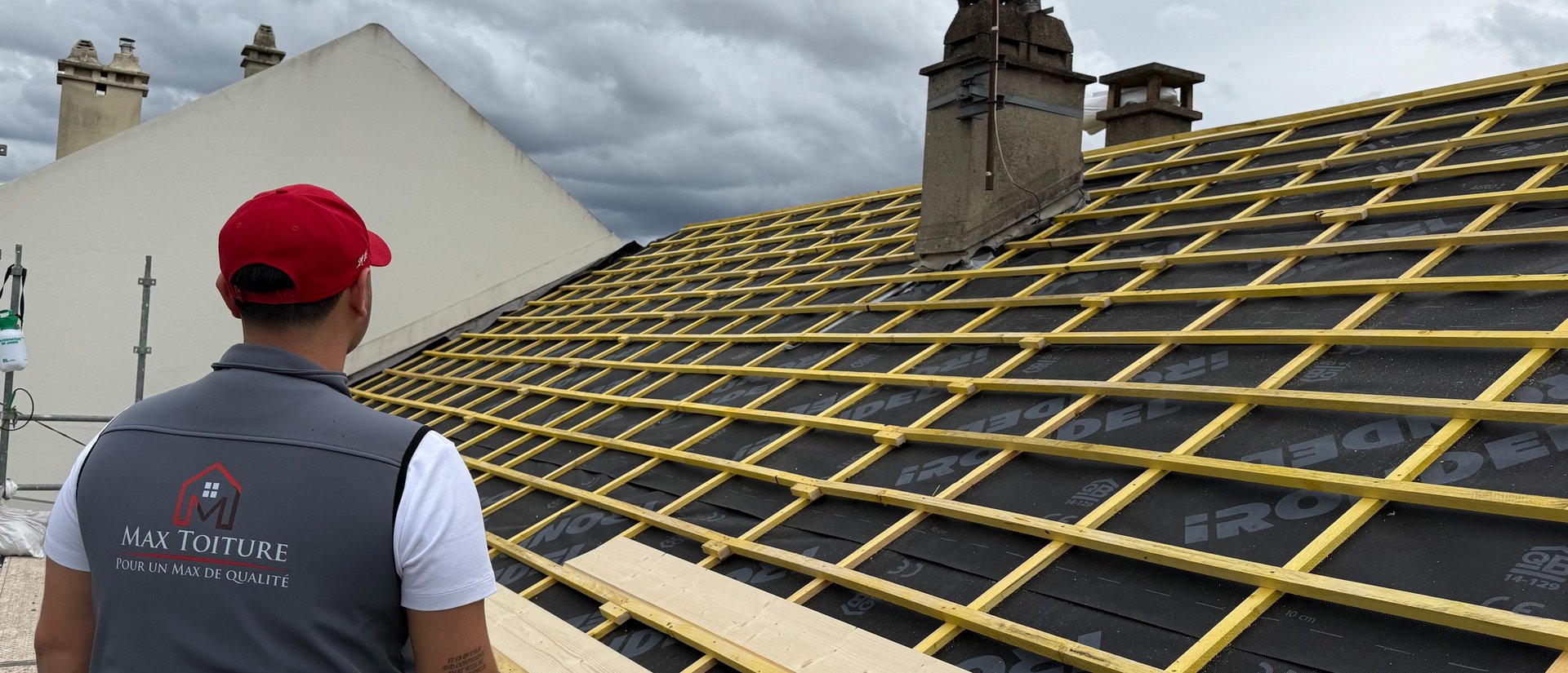 Roof tiles are being installed on a wooden frame.