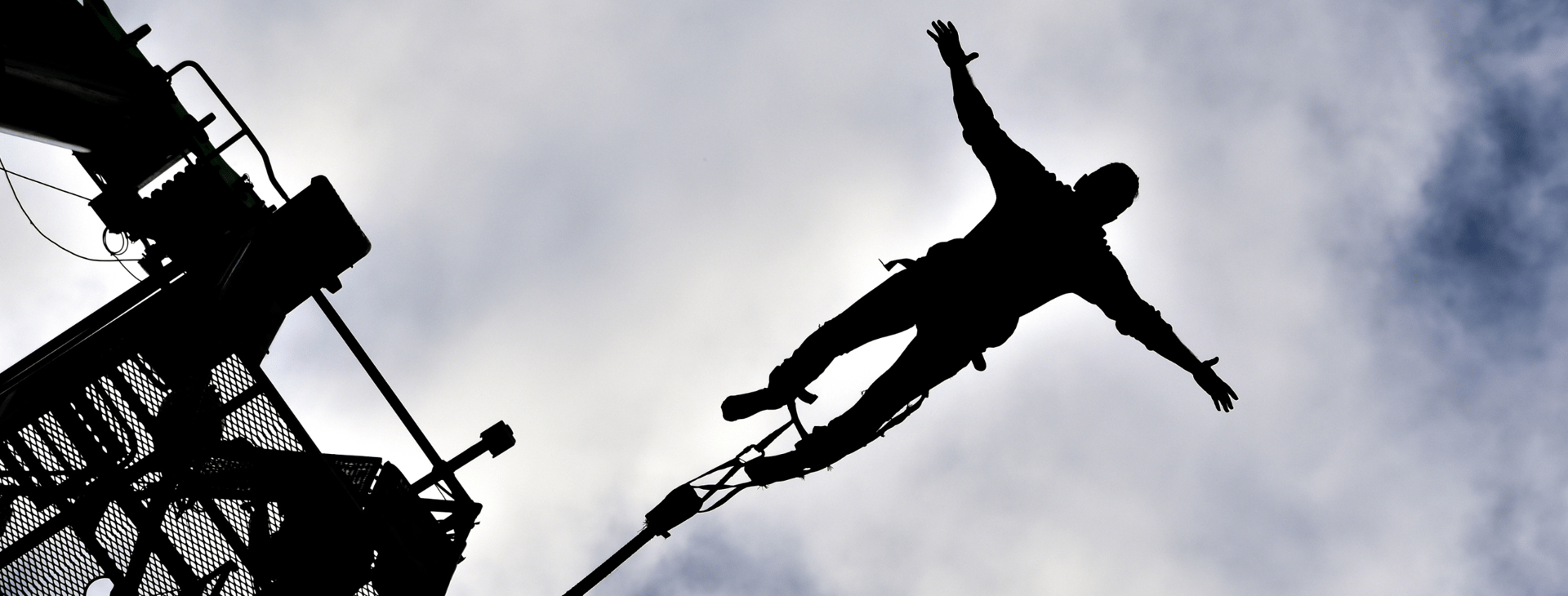 man jumping on body of water with rope