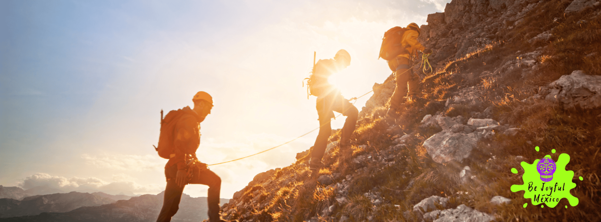 man in blue jacket and black pants standing on rock mountain during daytime