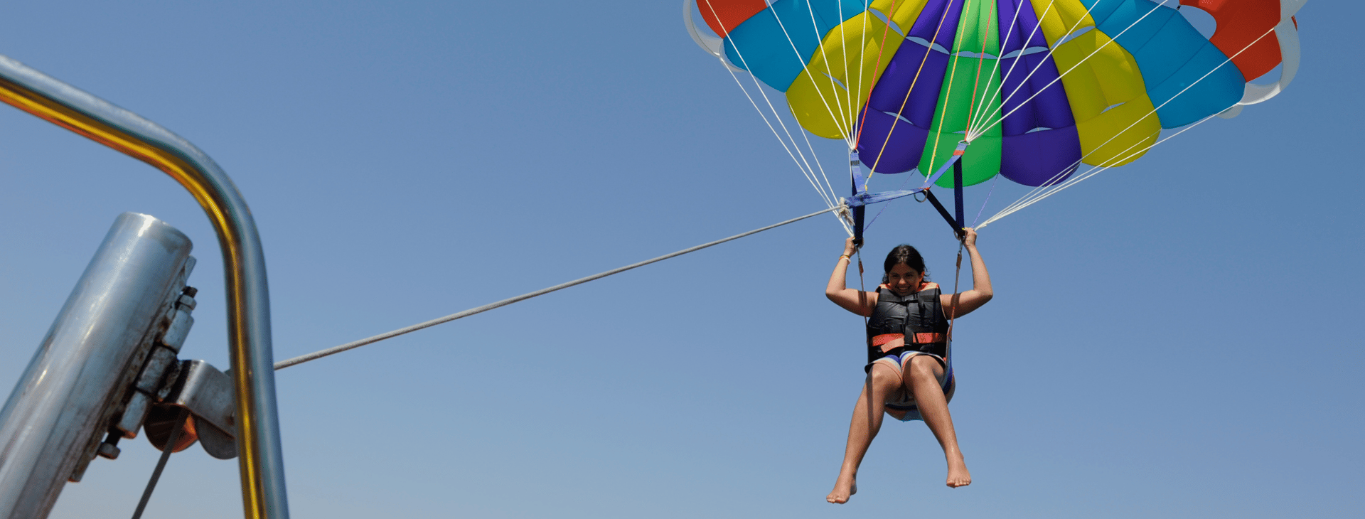 two person riding parachute near beach