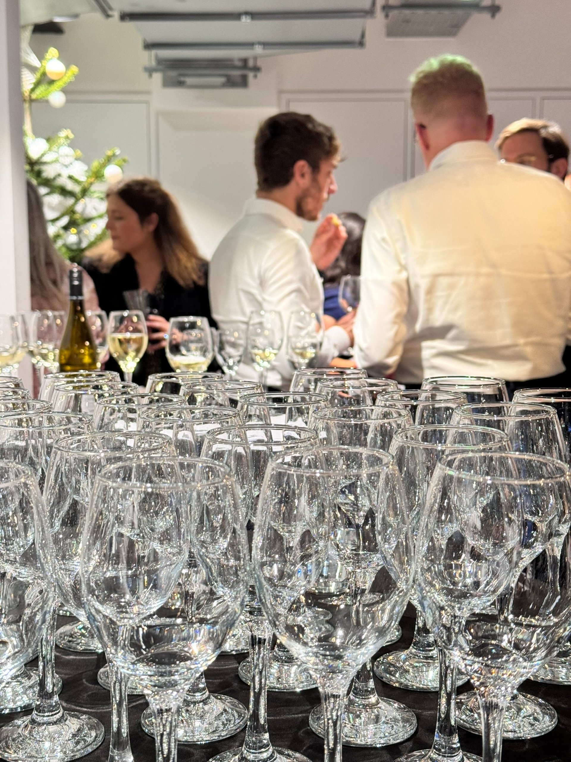 person putting wine on flute glass