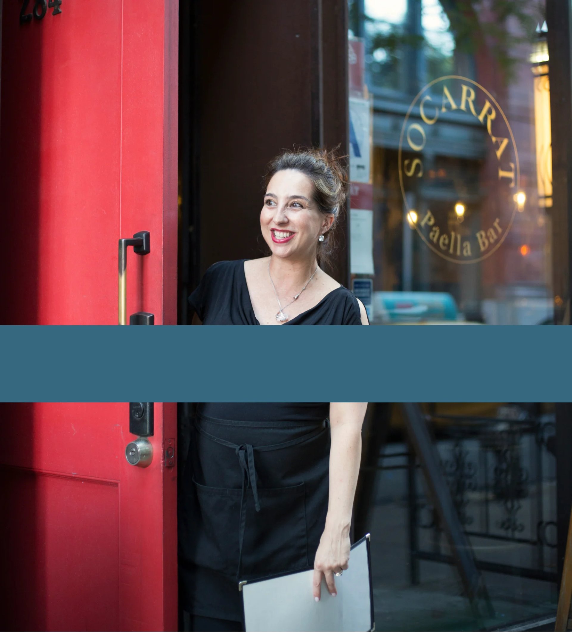 Smiling girl on the front of Socarrat NYC restaurant