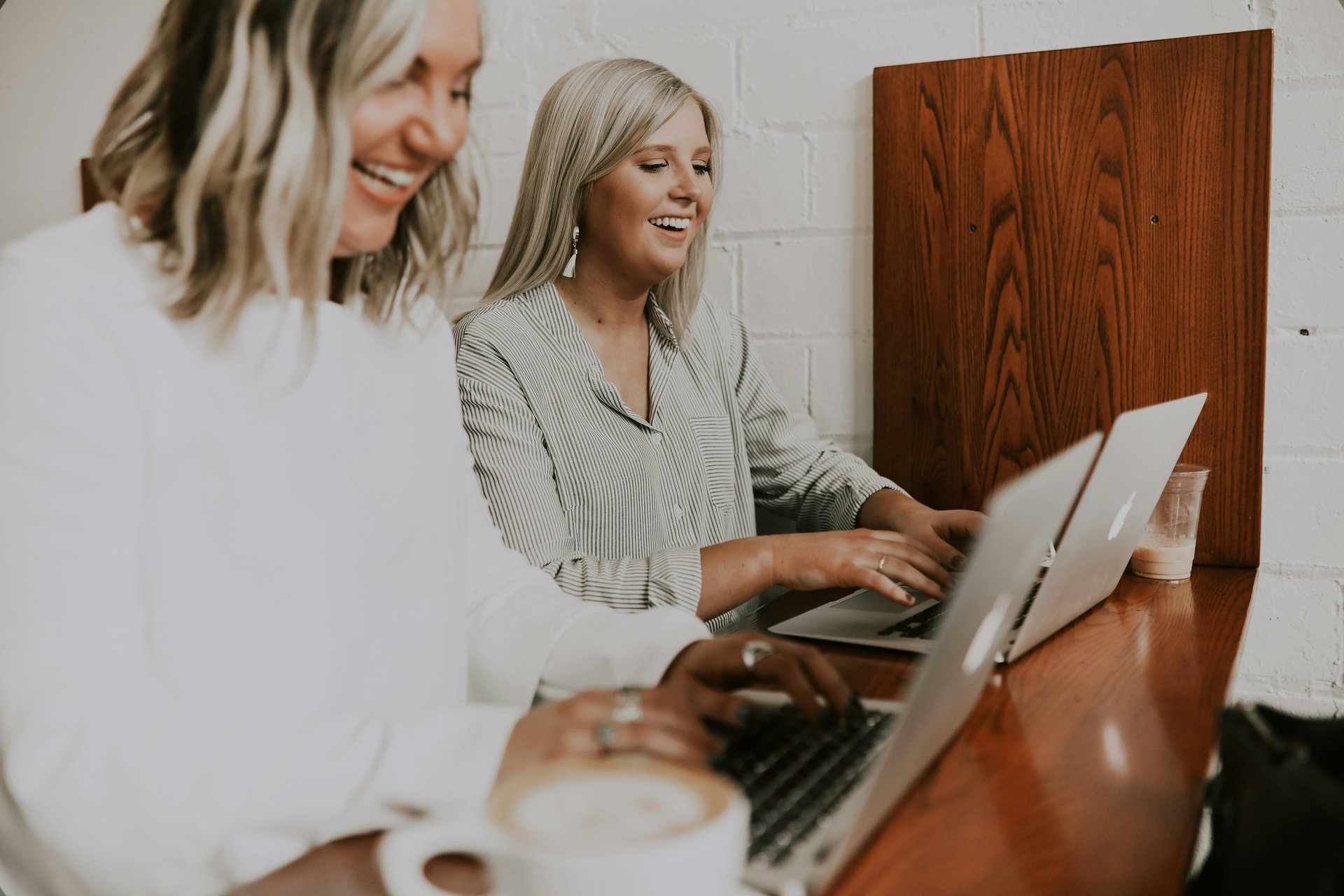 Two ladies are talking and working on the compiter