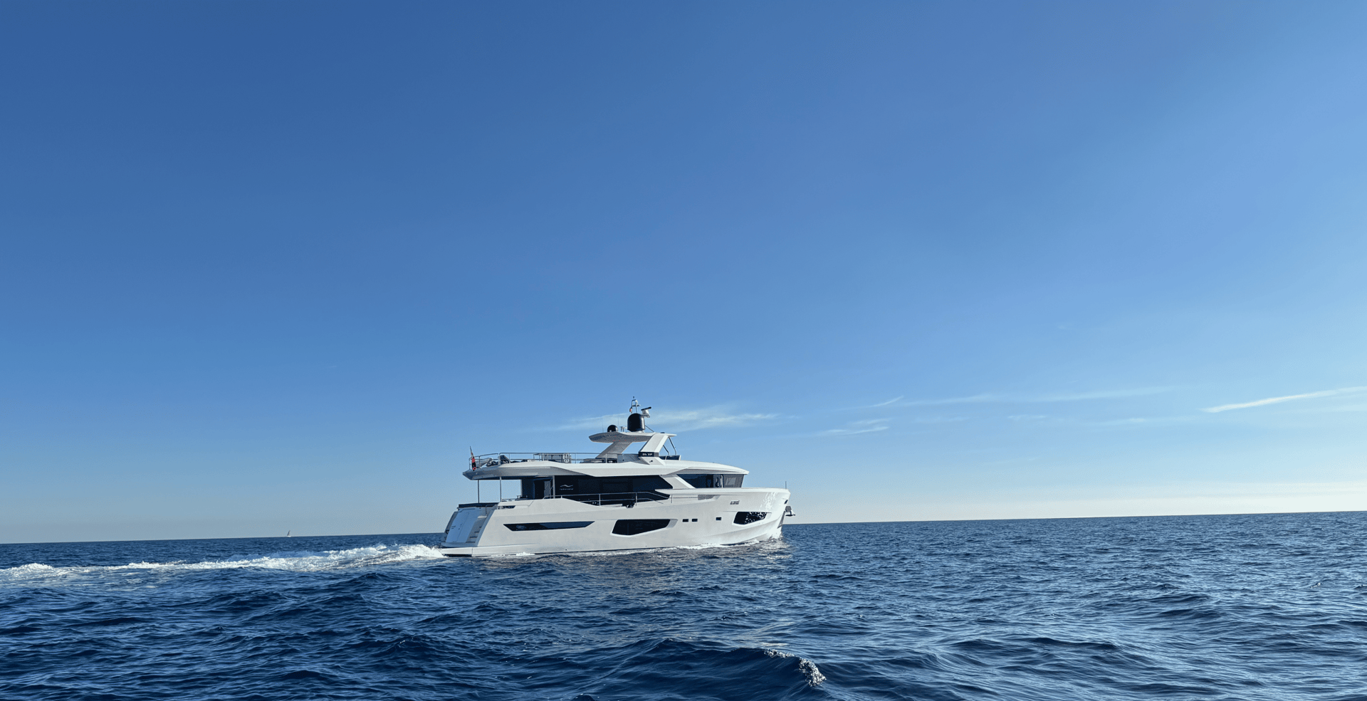 white and black yacht on sea under blue sky during daytime