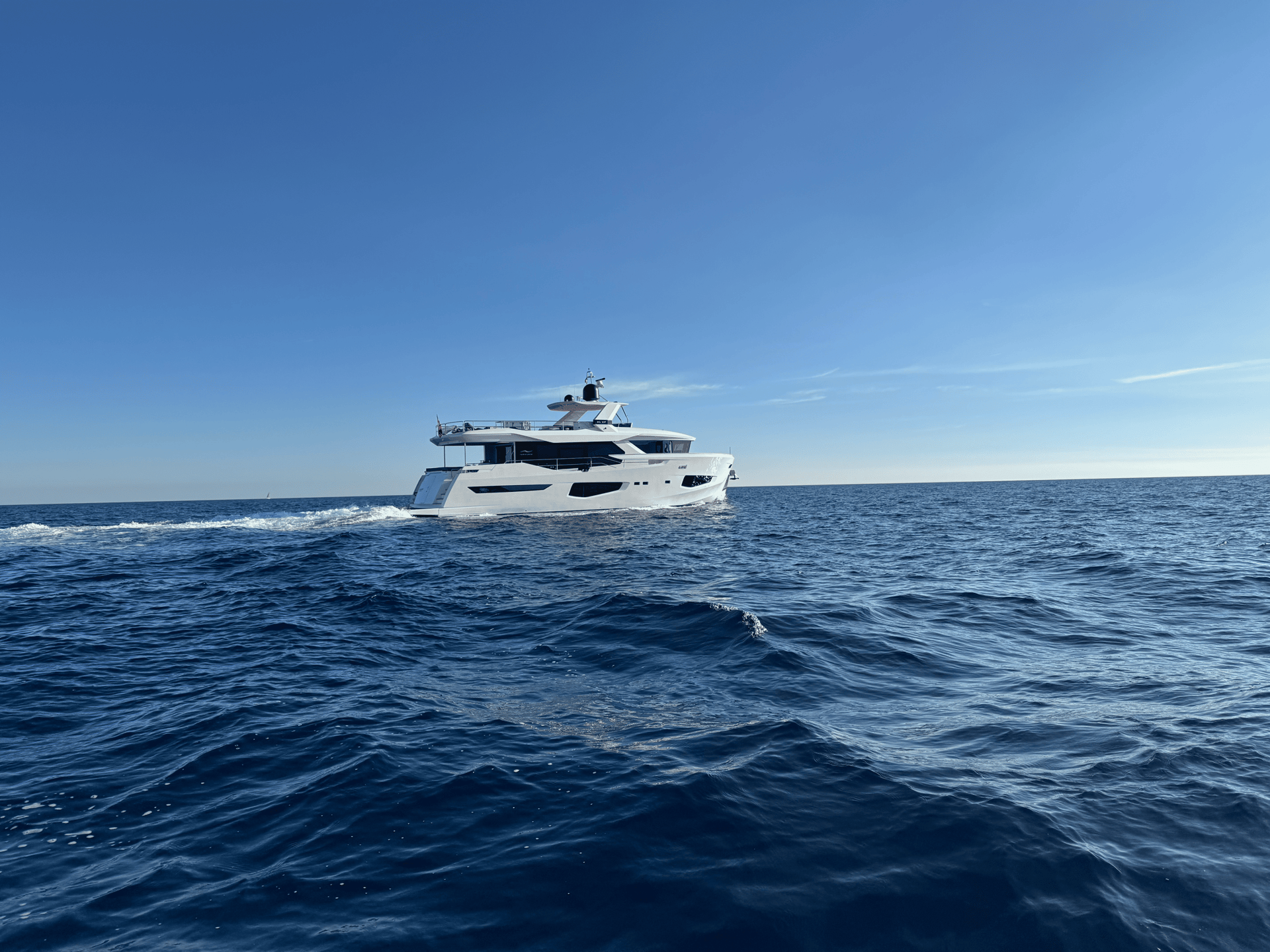 white and black yacht on sea under blue sky during daytime