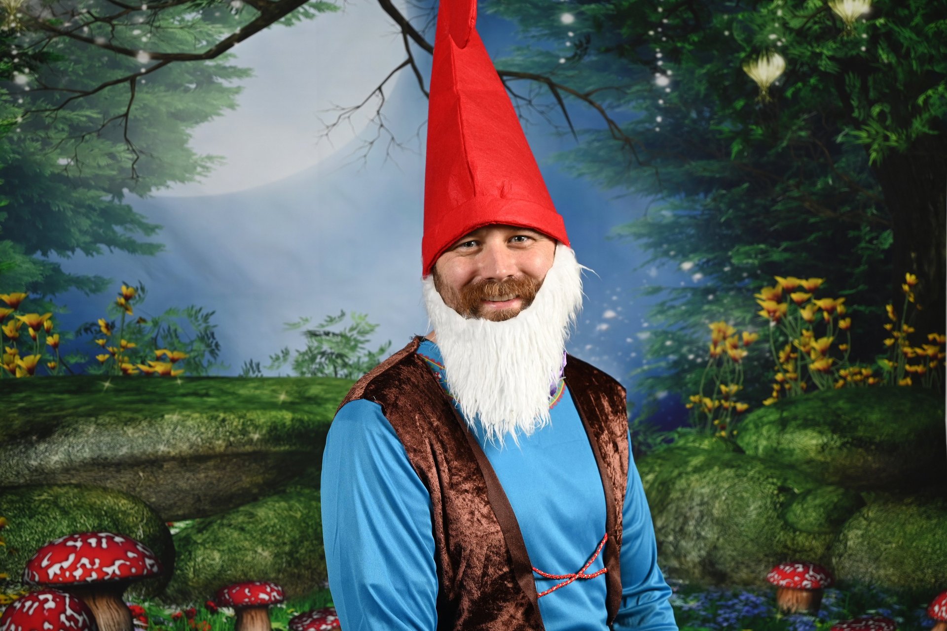 Me as a gnome in a woodland grove, giving the whackest Glamor Shot smile in history 