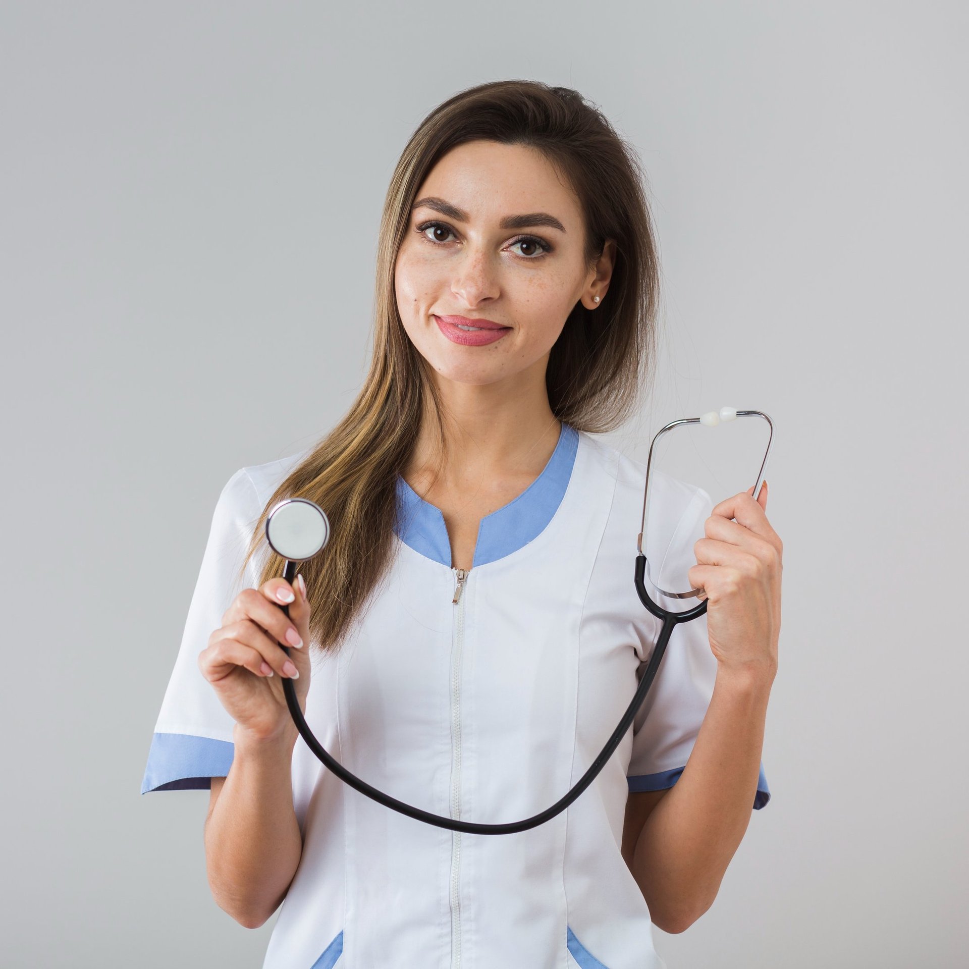 a woman in a white shirt holding a stethoscope