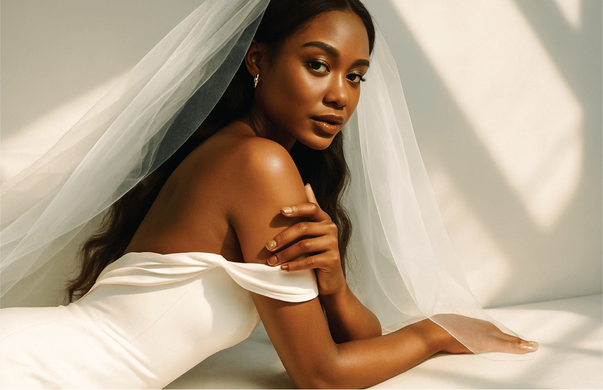 woman in wedding dress standing near window looking outside while holding the curtains