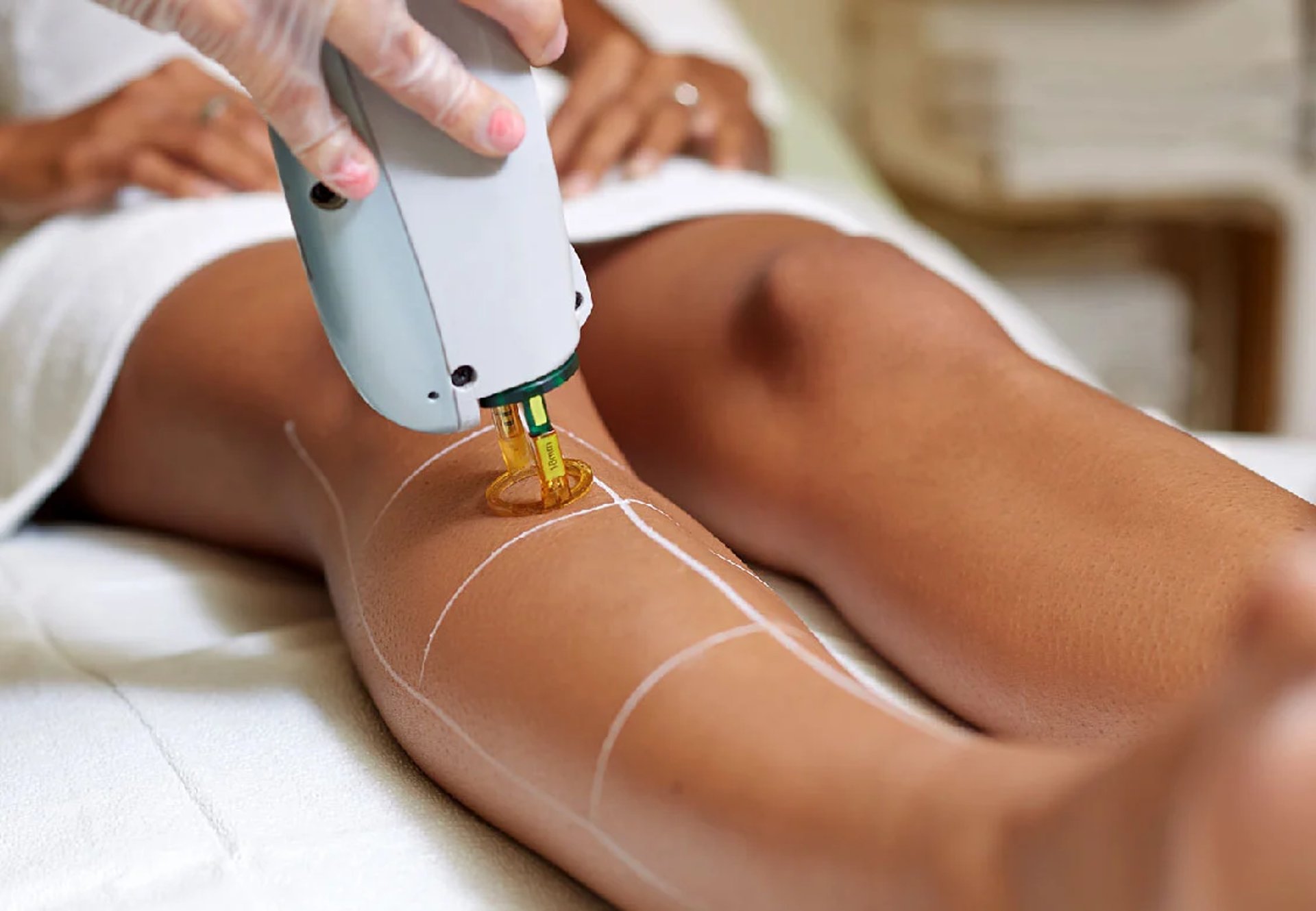 a woman laying on top of a bed holding a hair dryer