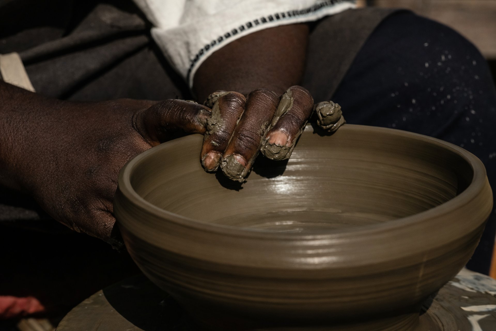 a man is making a bowl on a potter's wheel