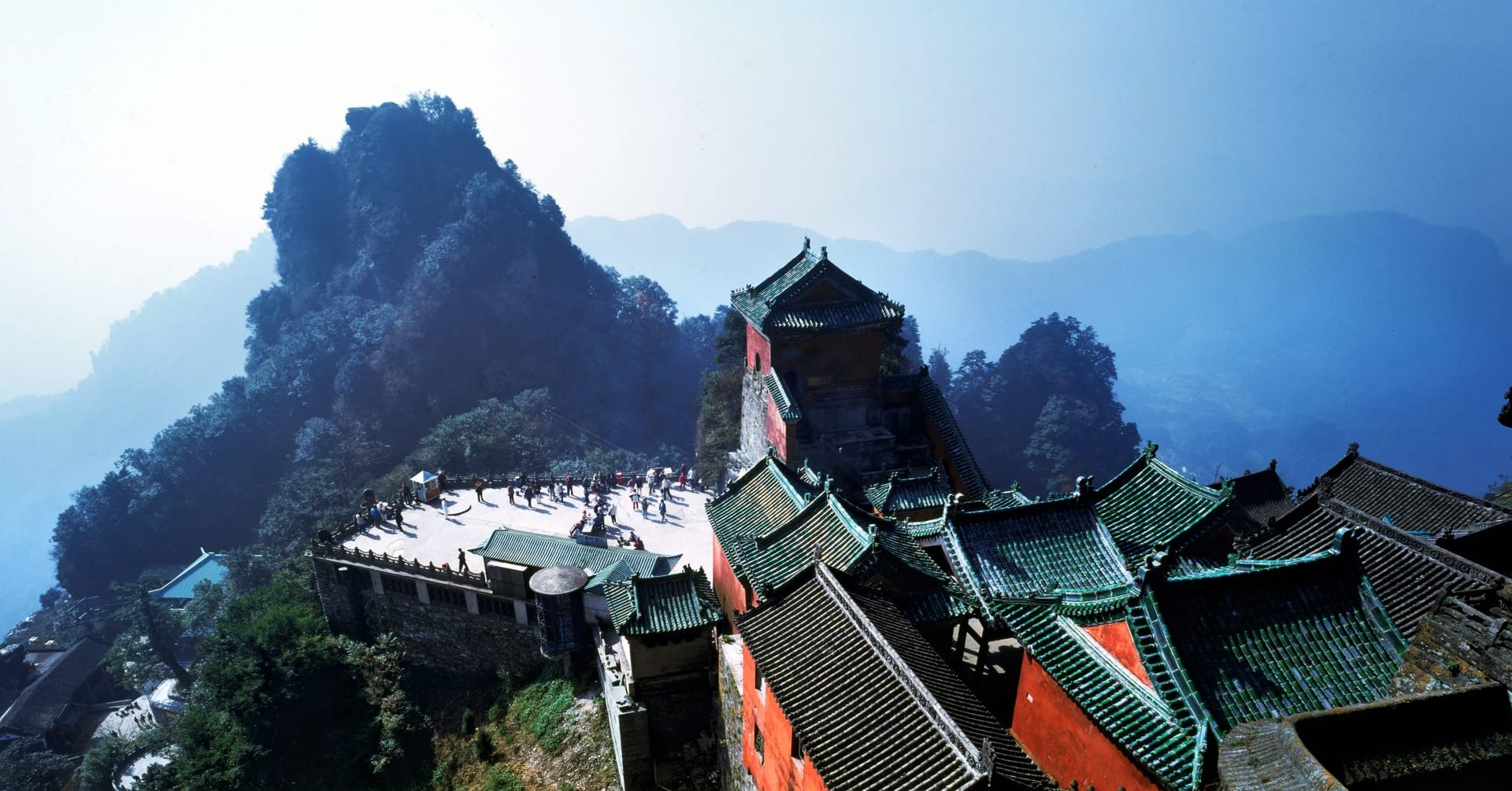 Çin Wudang Dağları'nda sisli dağ zirveleri ve tarihi tapınak kompleksi manzarası.