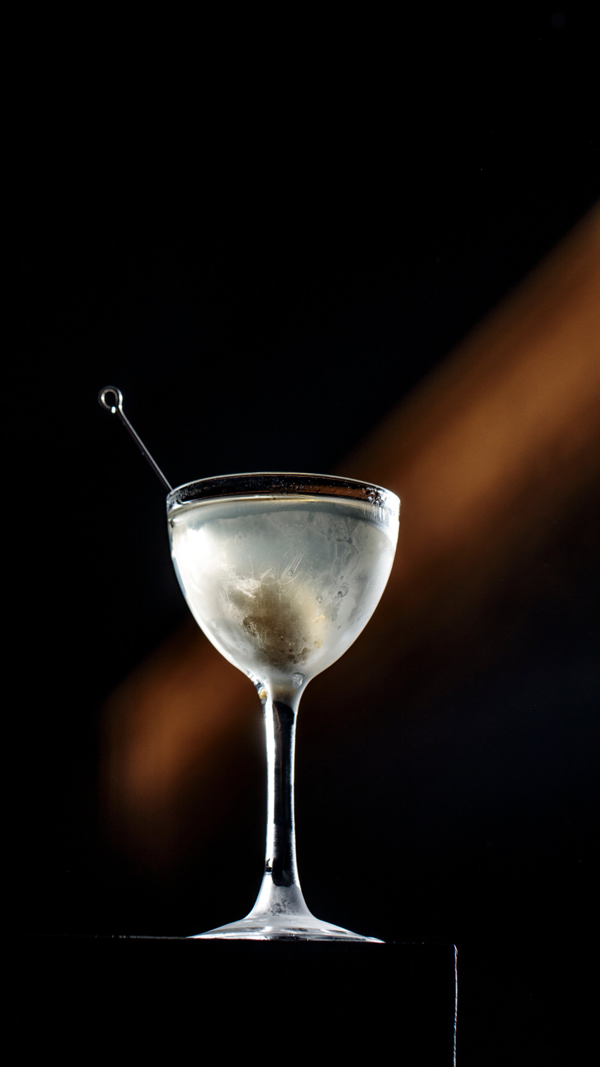 a glass of alcohol sitting on a table next to a couch