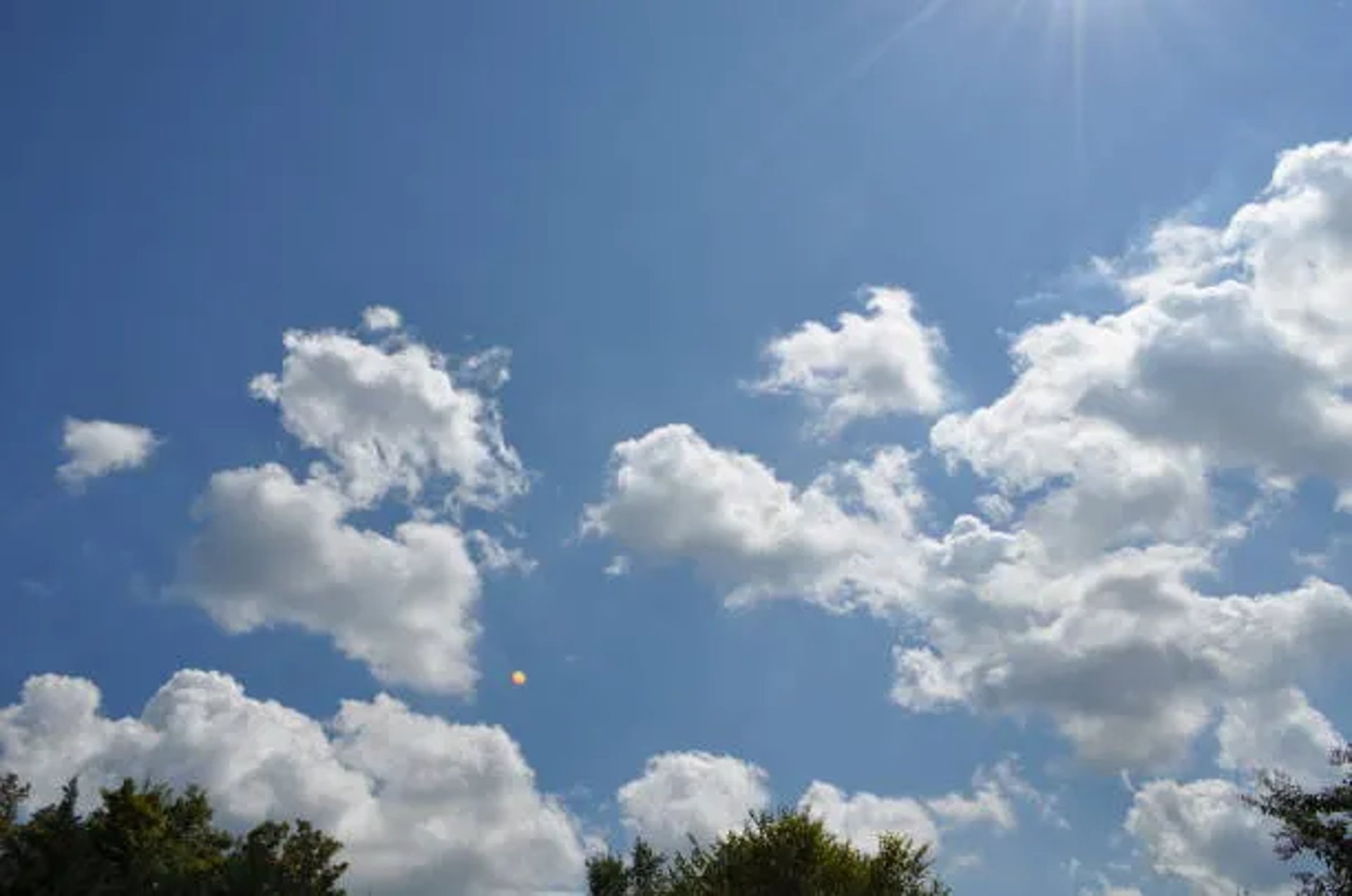 woman wearing yellow long-sleeved dress under white clouds and blue sky during daytime