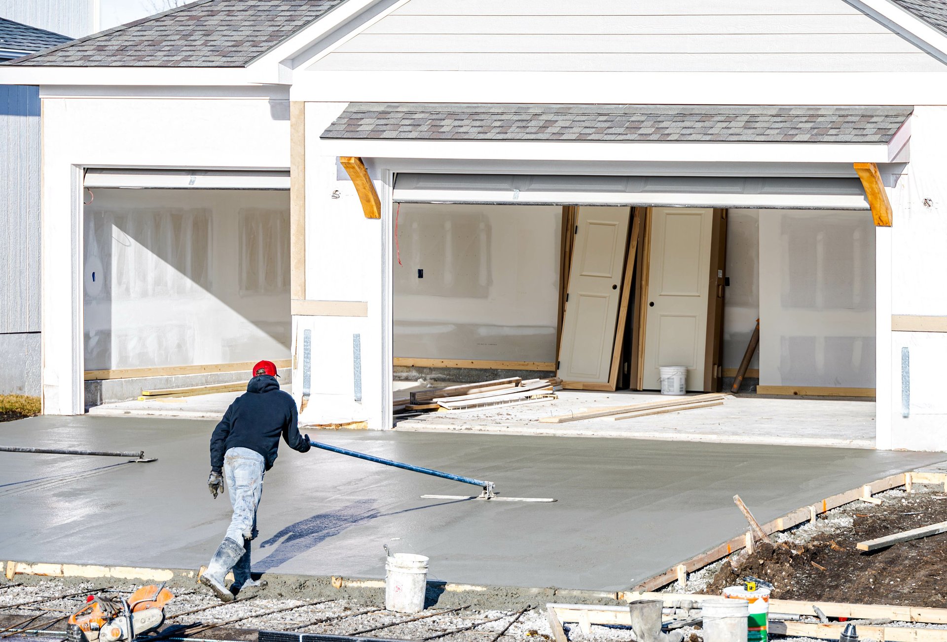 a man polishing a freshly poured concrete in the driveway
