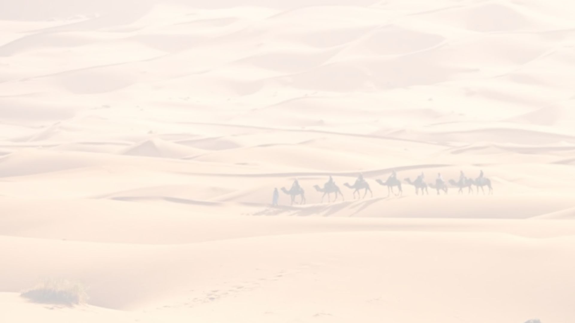 green grass field near mountain under white clouds during daytime