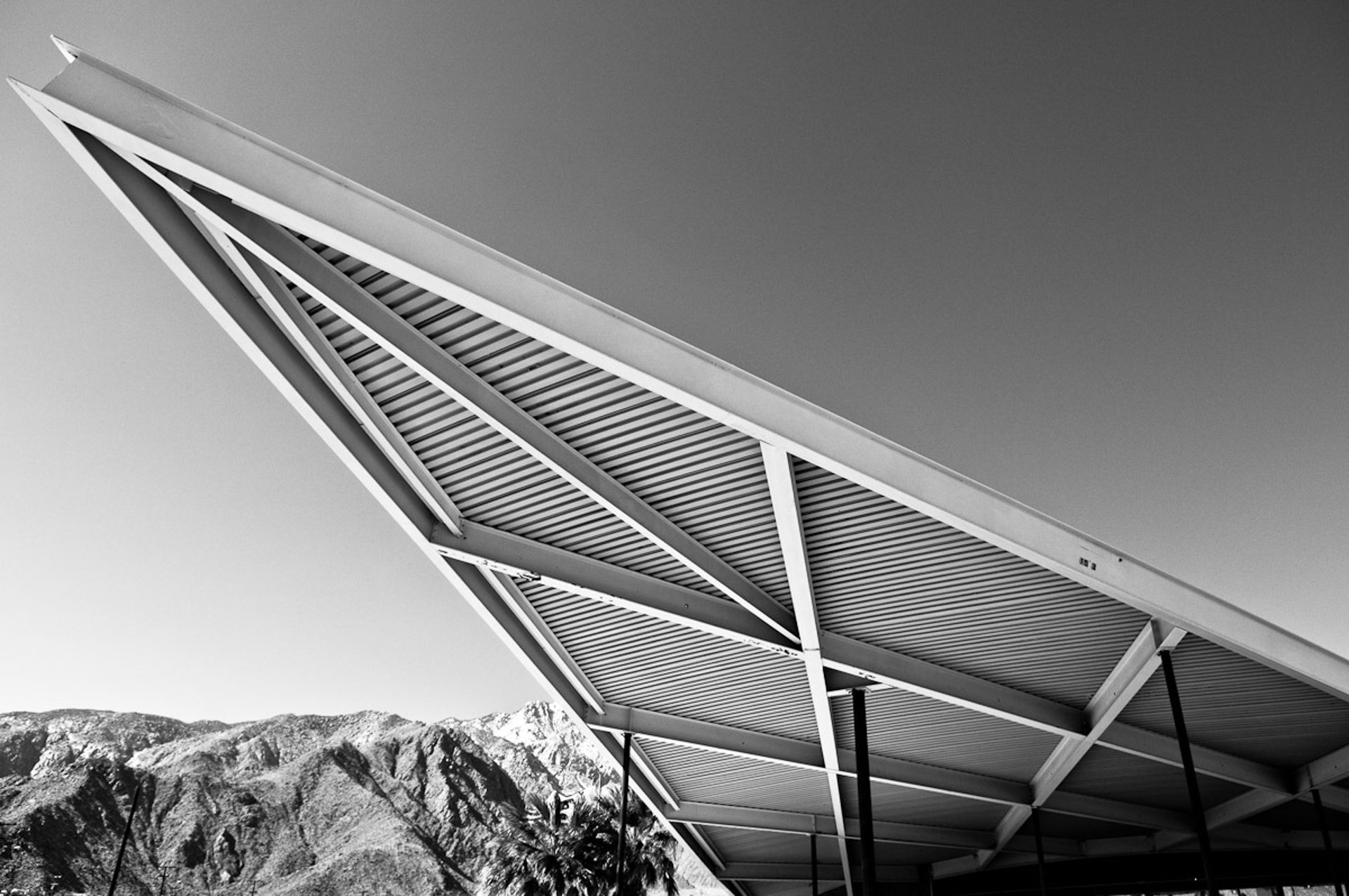 an abstract photo of a curved building with a blue sky in the background
