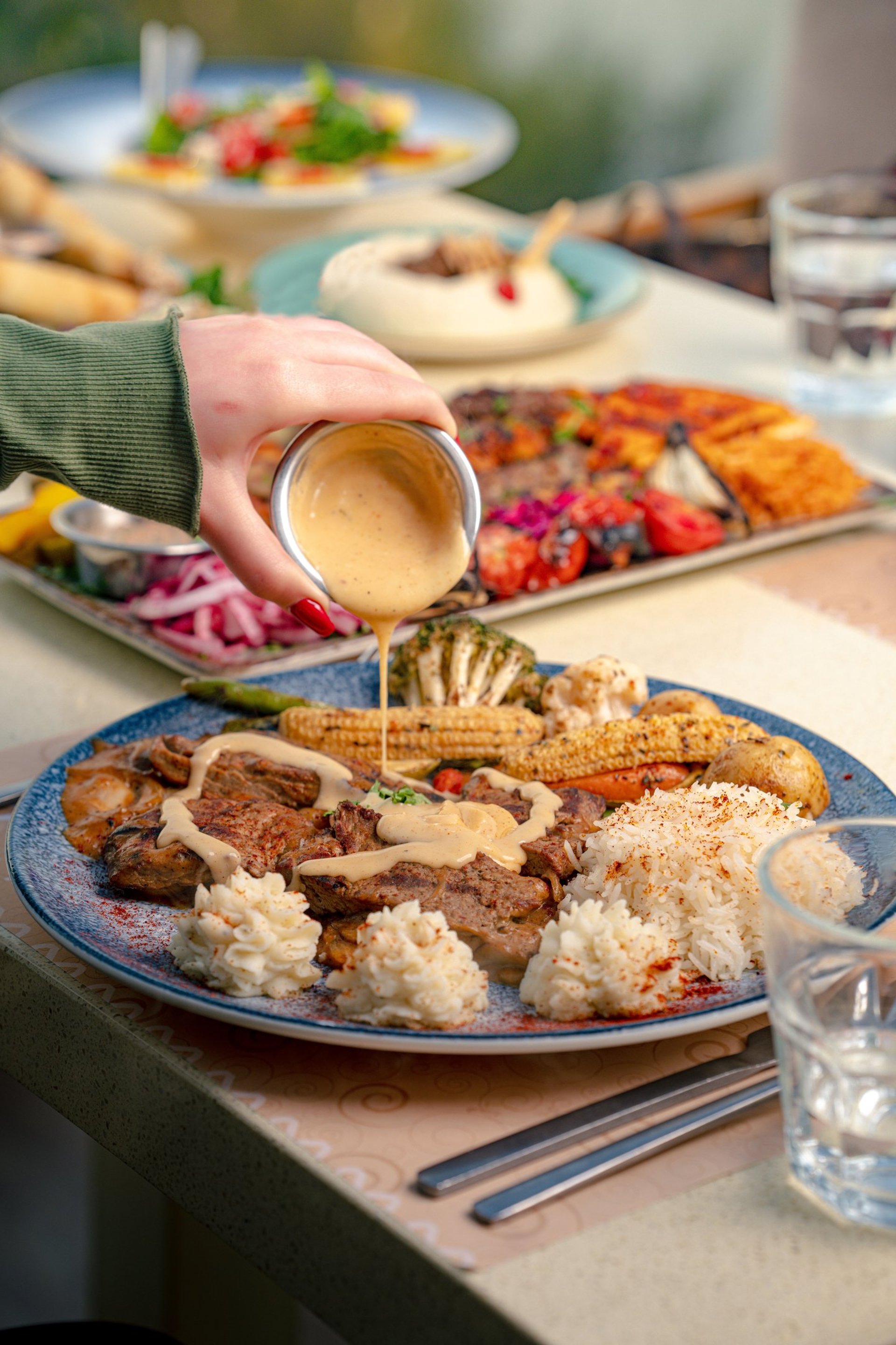 a blue bowl filled with vegetables and a wooden spoon