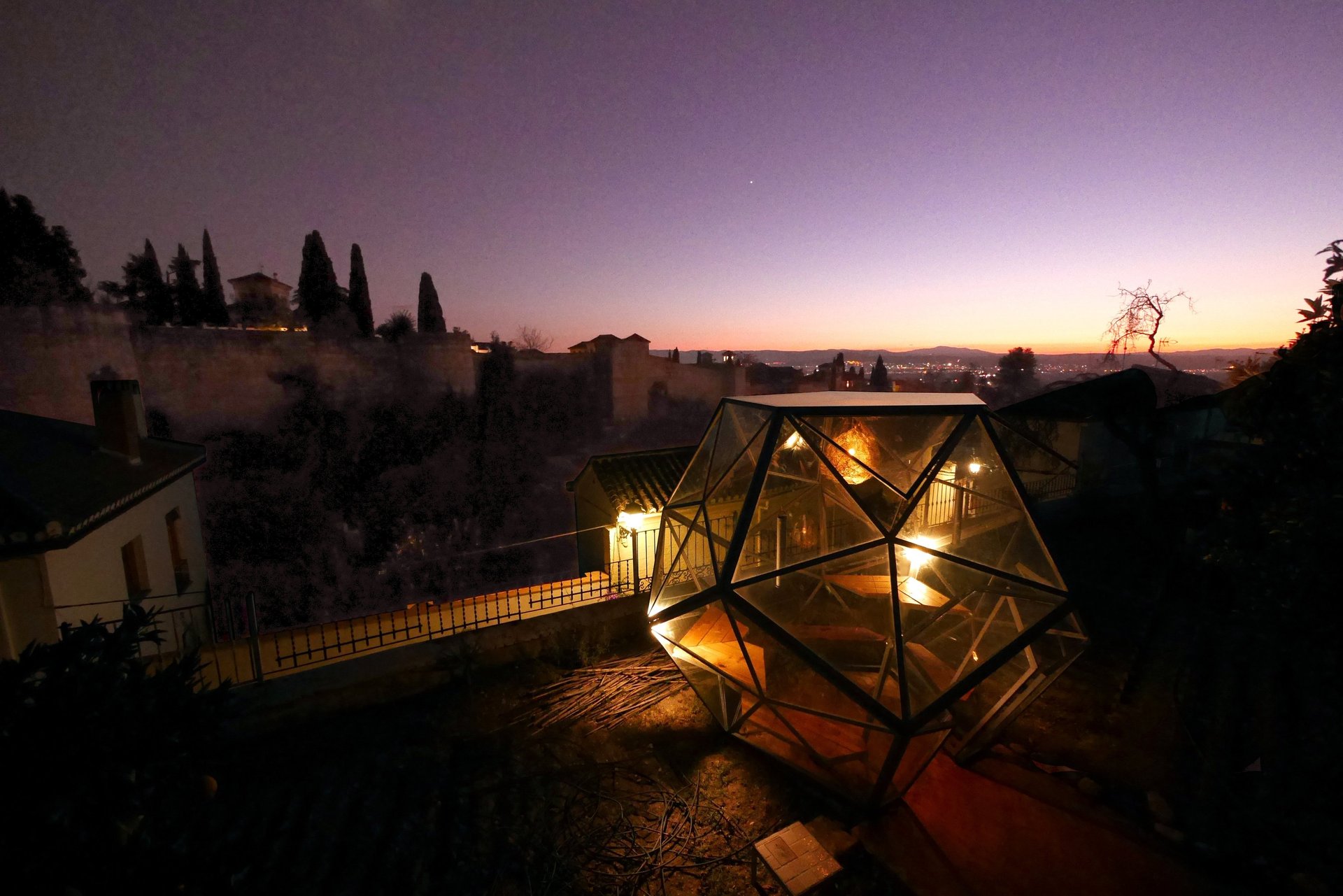 Large-scale illuminated art installation in open desert landscape at sunset