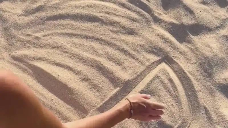 Video: Valeria Angeletti disegna il logo Metabolika sulla sabbia alle dune di Corralejo, simbolo di equilibrio e rinascita.