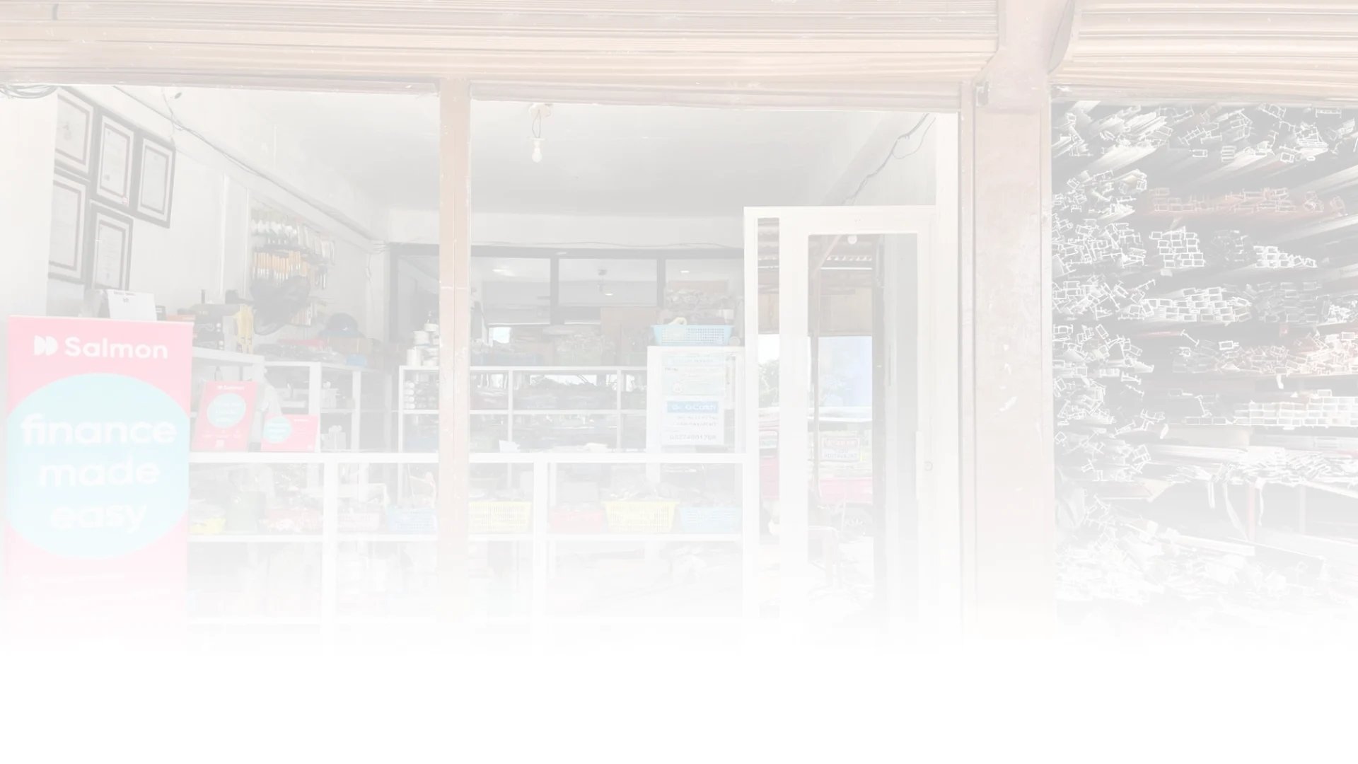 A storefront with a "Salmon finance made easy" banner, showcasing shelves of hardware and supplies inside.