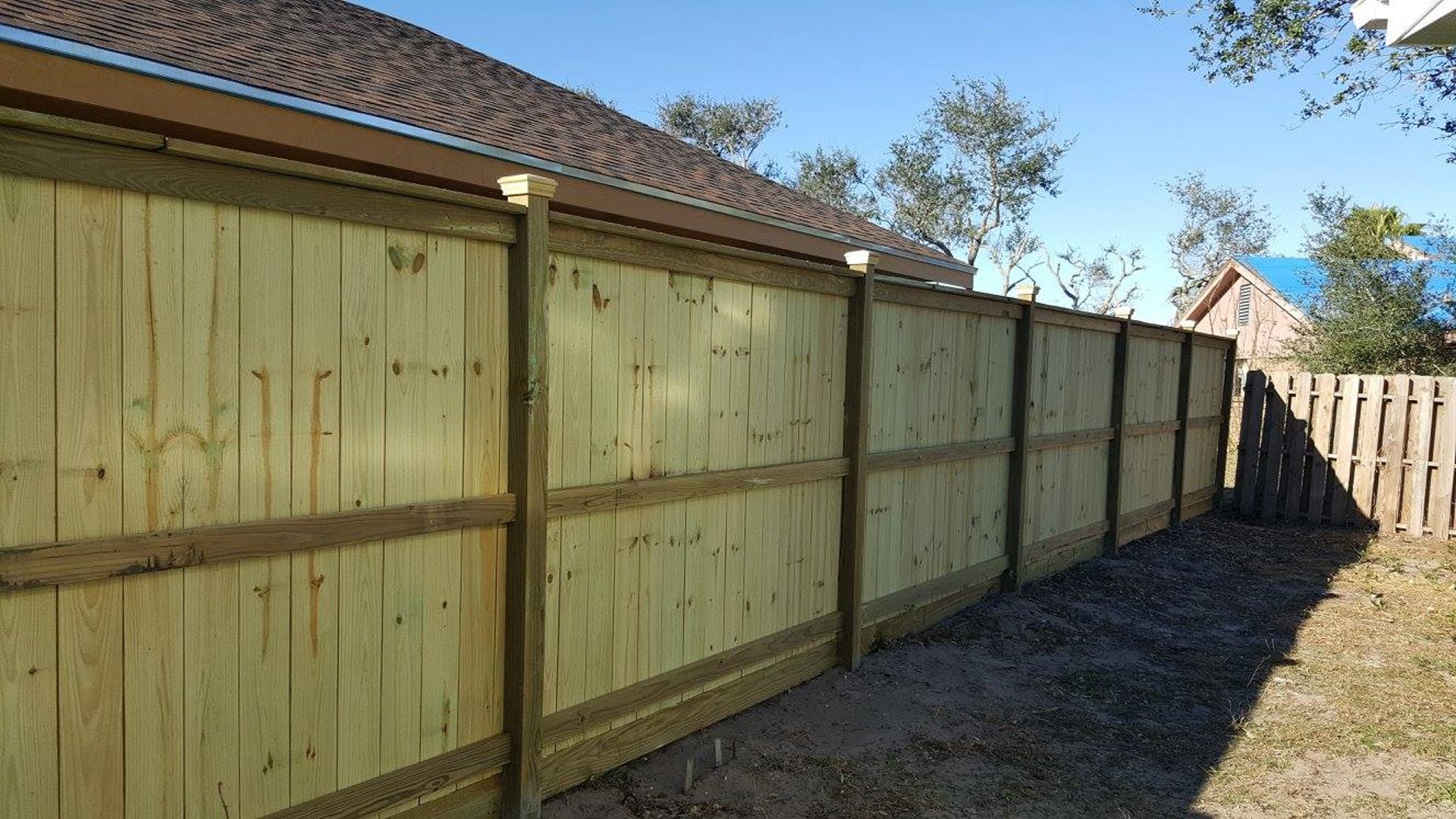 green grass beside brown wooden fence