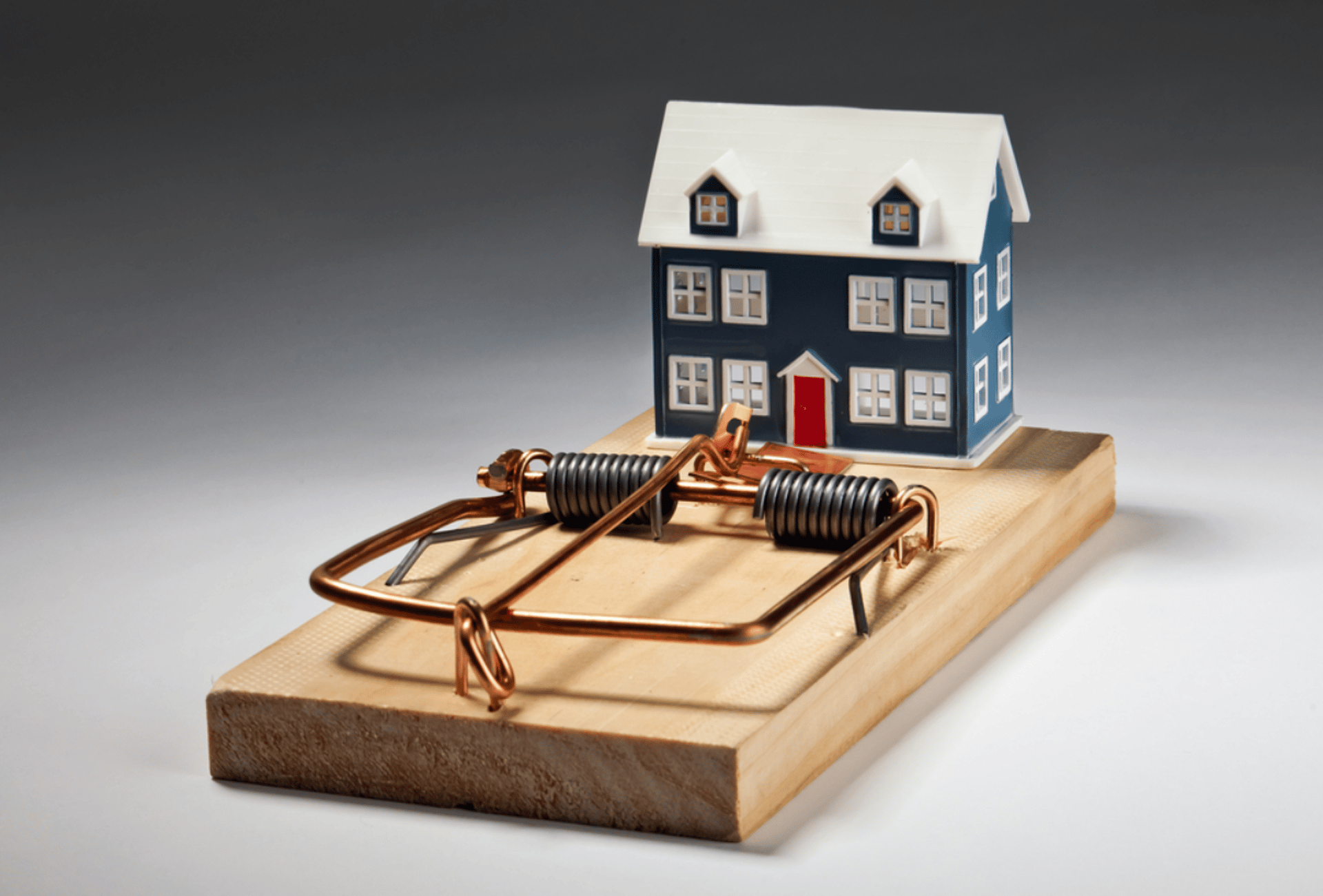 A hand reaching for a pink house in front of a row of houses