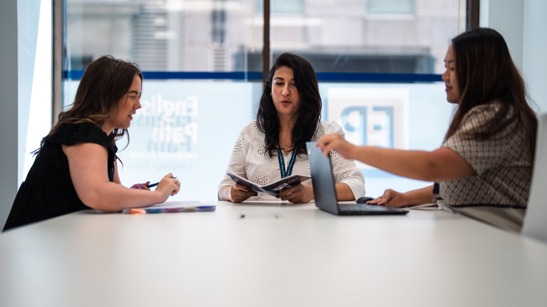 a woman in a blue cardigan pointing to the side