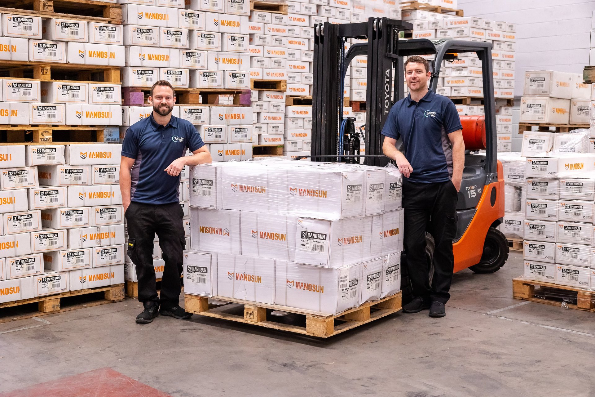 man in gray shirt standing beside brown cardboard boxes