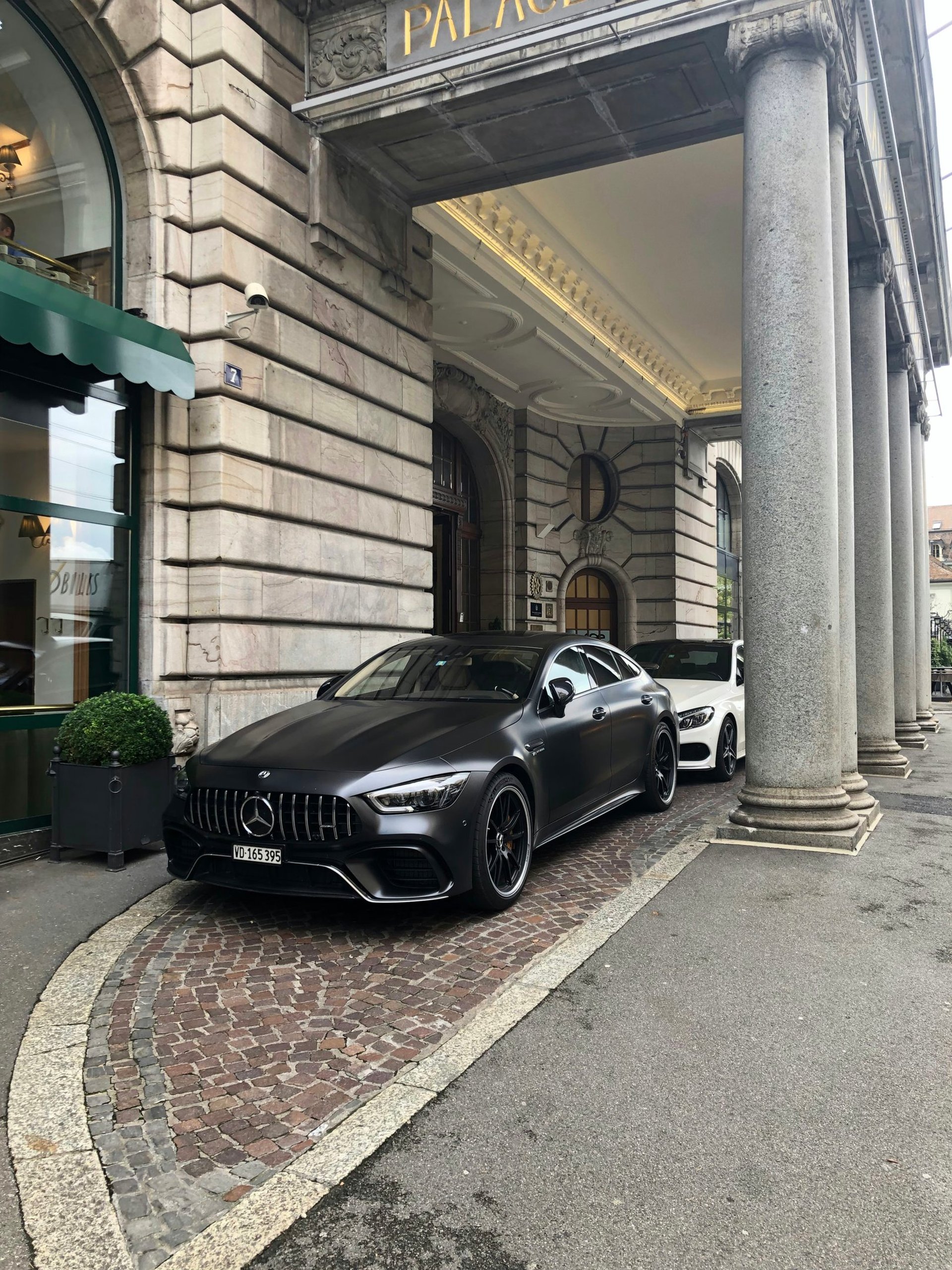 Two sports cars parked outside of an hotel