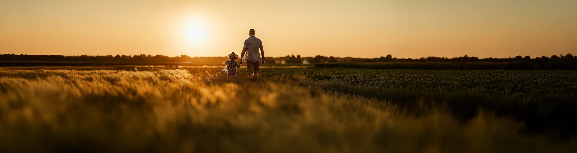 human in yellow long-sleeved T-shirt walking beside white concrete wall