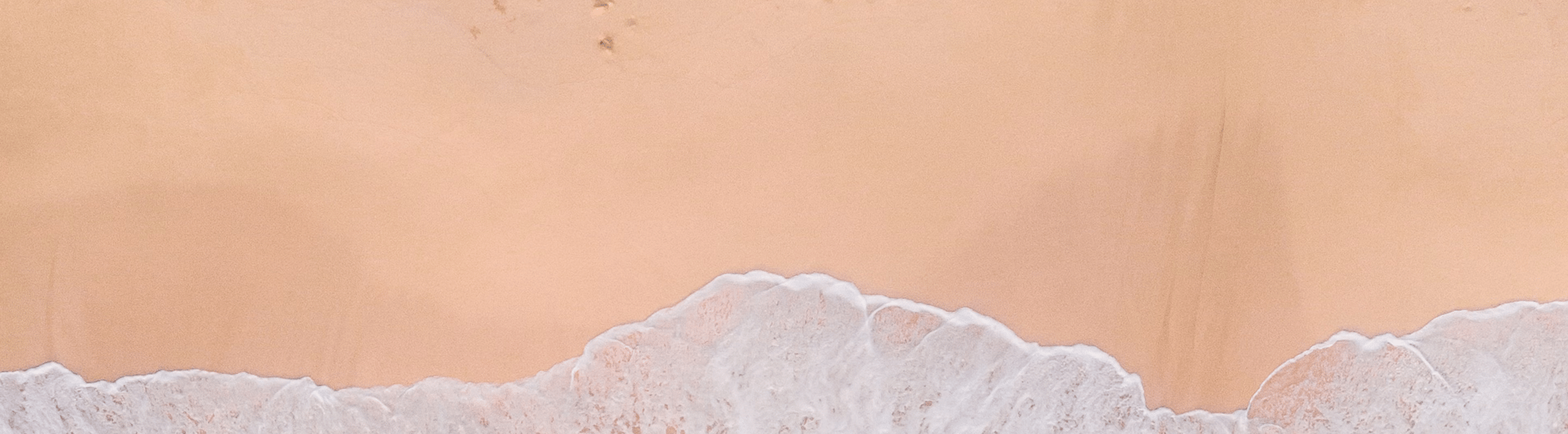 aerial photography of waves splashing on white sand beach