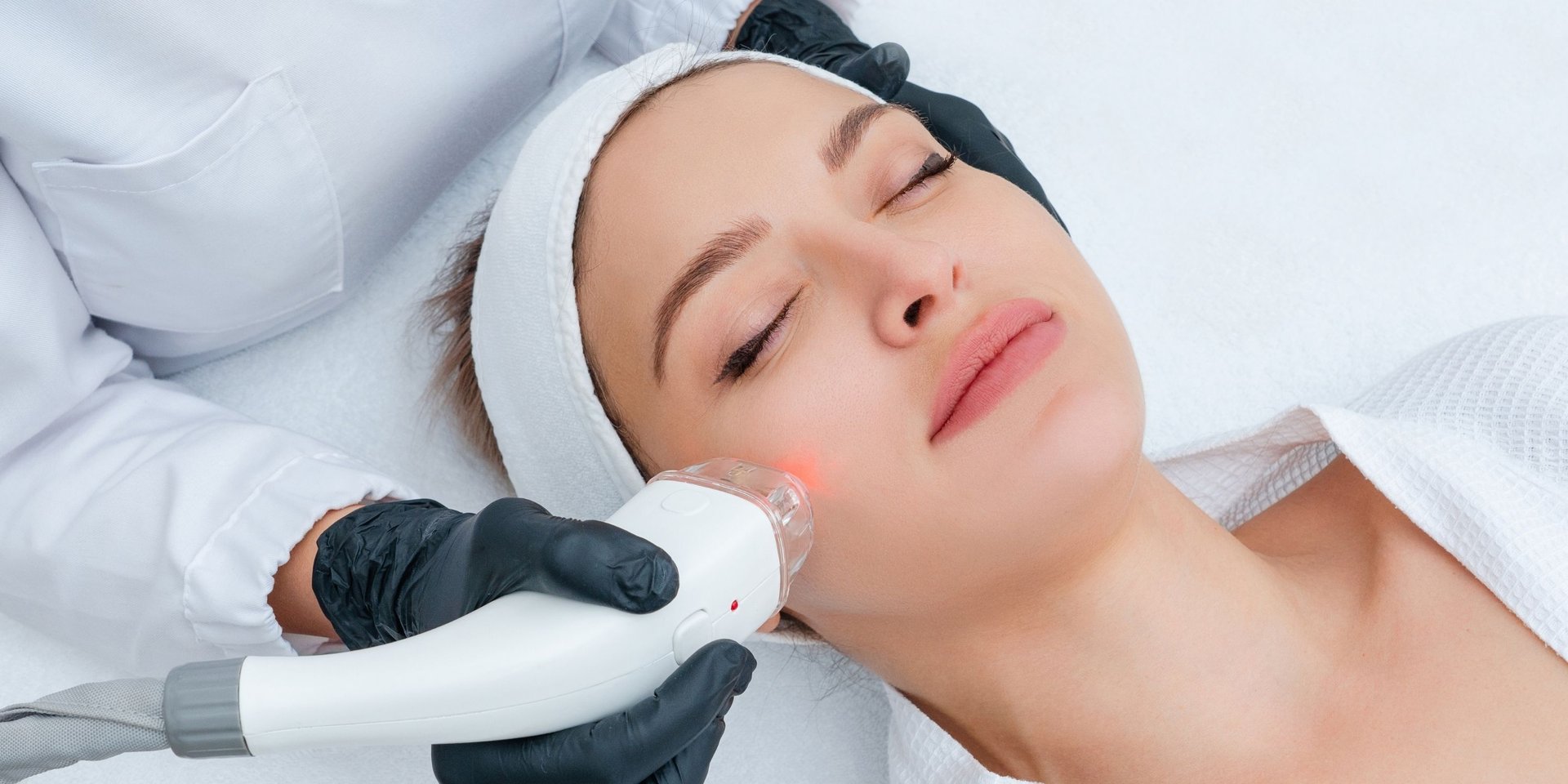 woman lying on blue towel with white cream on face