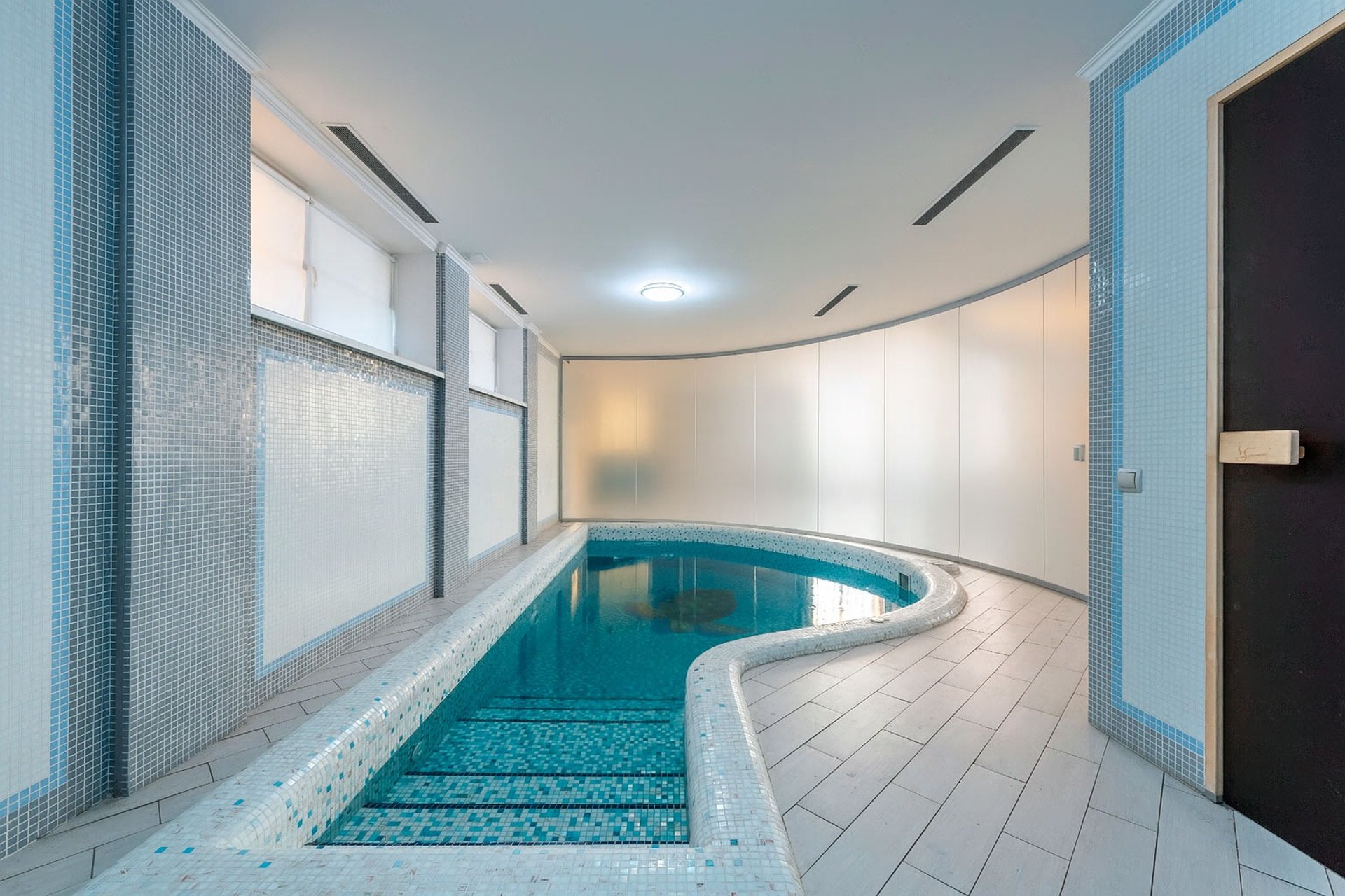 Hotel pool bathroom privacy glass wall, opaque mode on demand.
