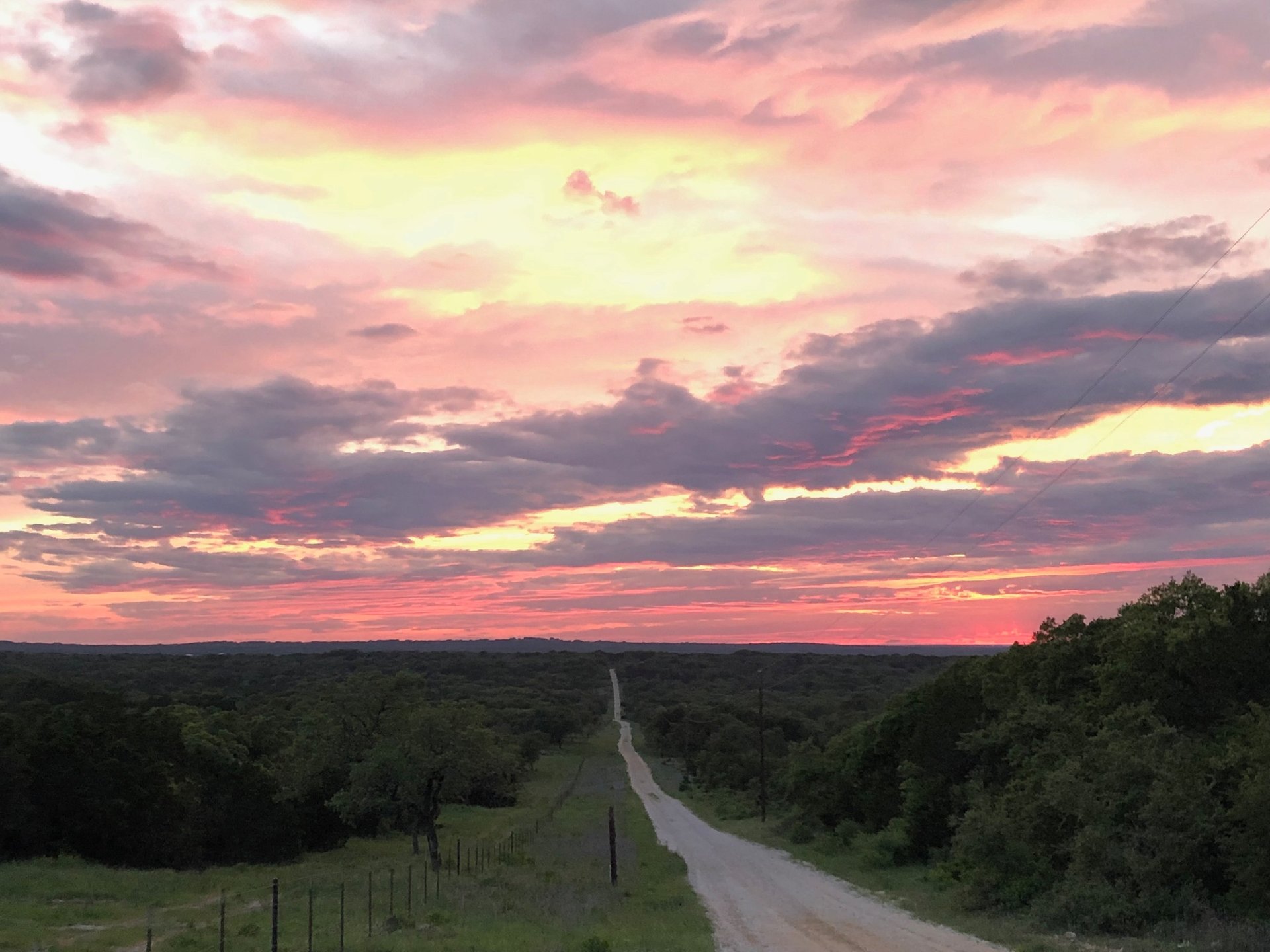 Hill country sunset view from a hilltop road.