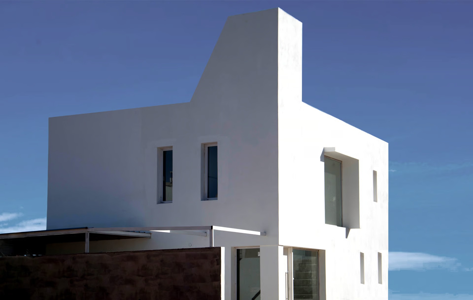 an abstract photo of a curved building with a blue sky in the background