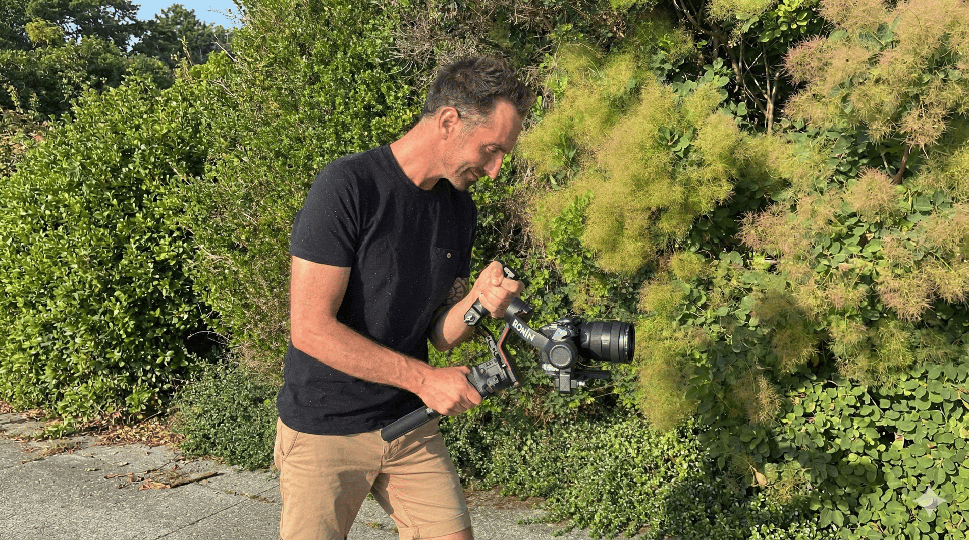 green grass covered mountain beside body of water under white clouds during daytime