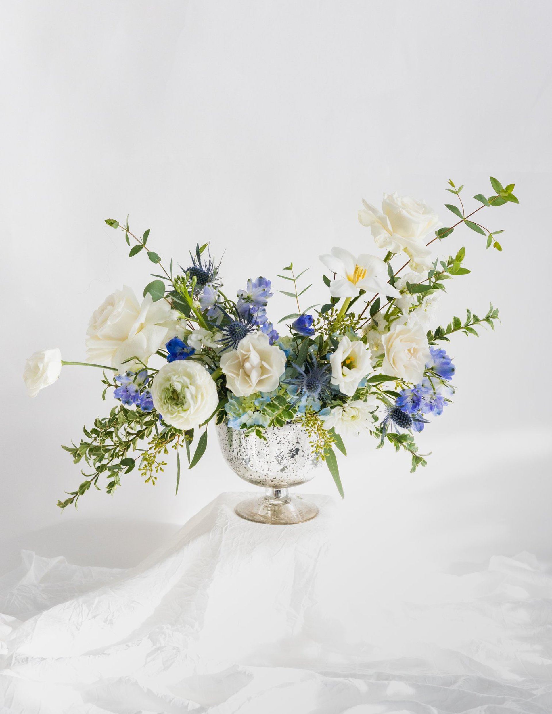 A vase filled with lots of flowers on top of a table