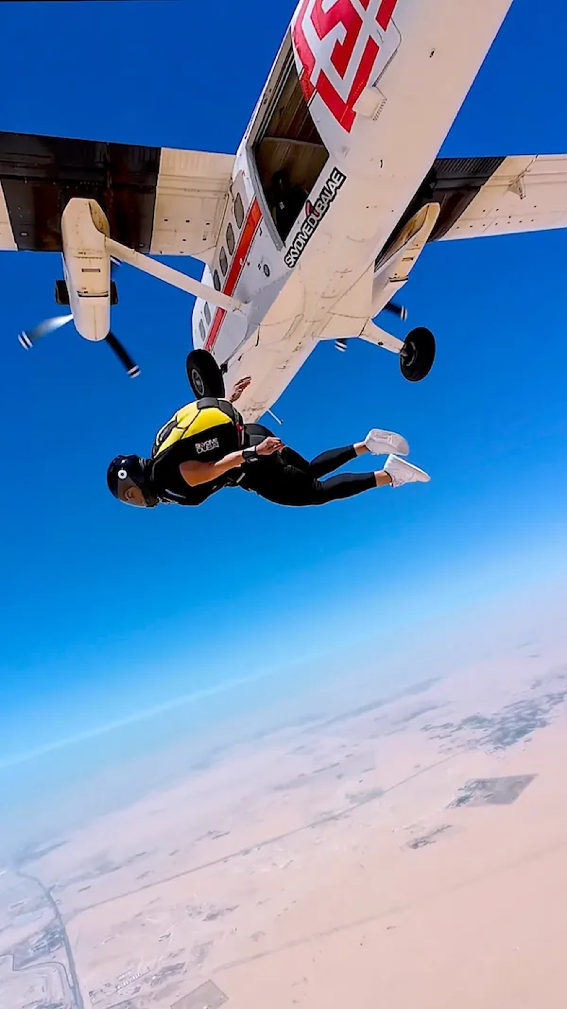 mais alhajri skydiving in yellow and black jumpsuit after jumping from a plane