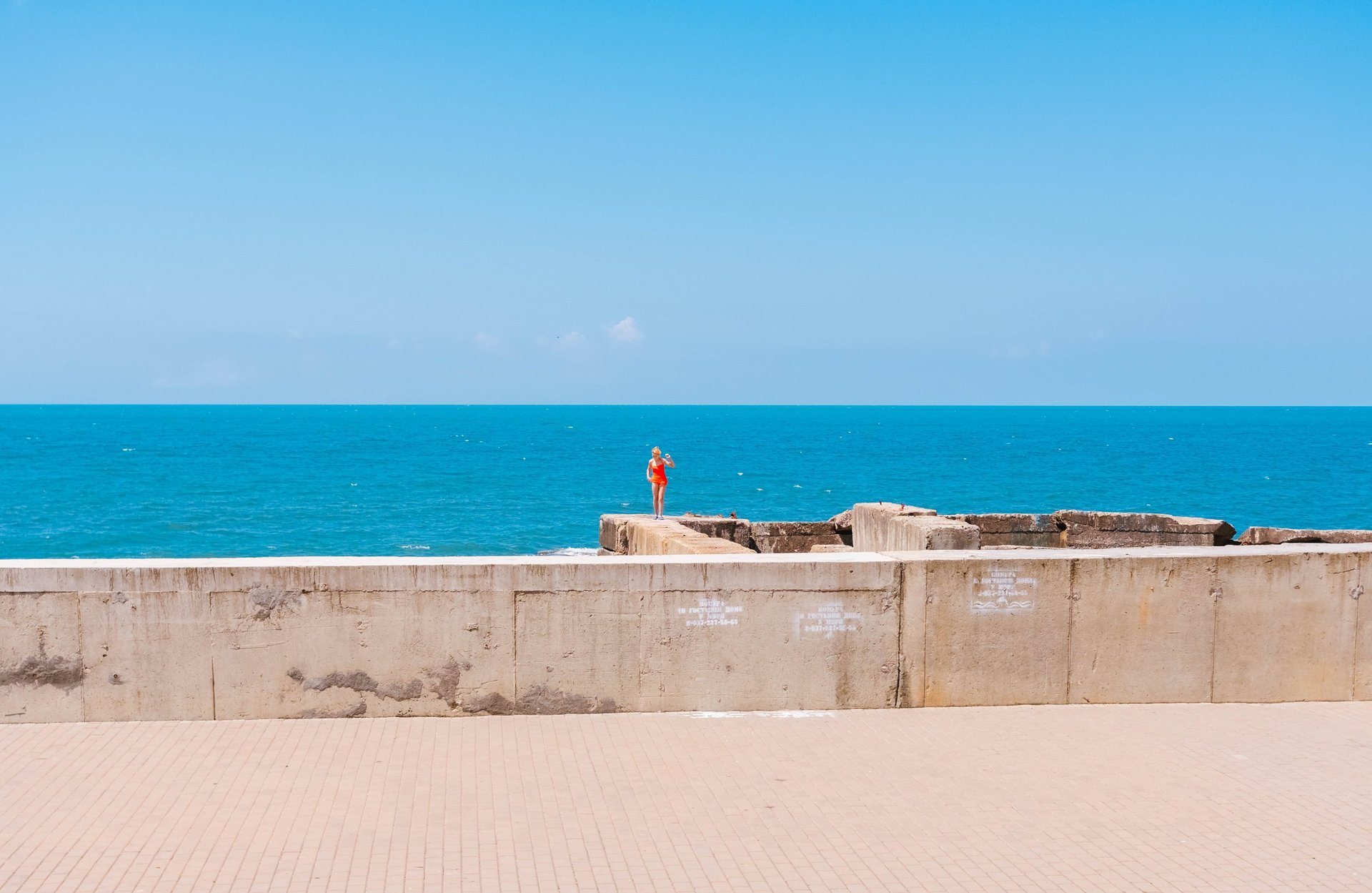 a concrete wall next to a body of water