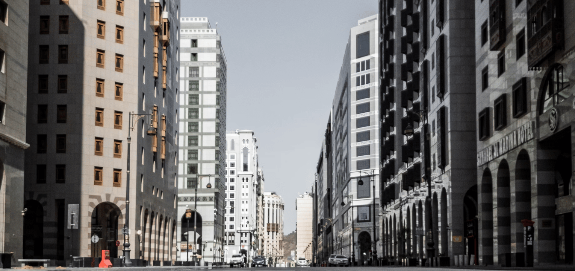 cars on road between high rise buildings during daytime