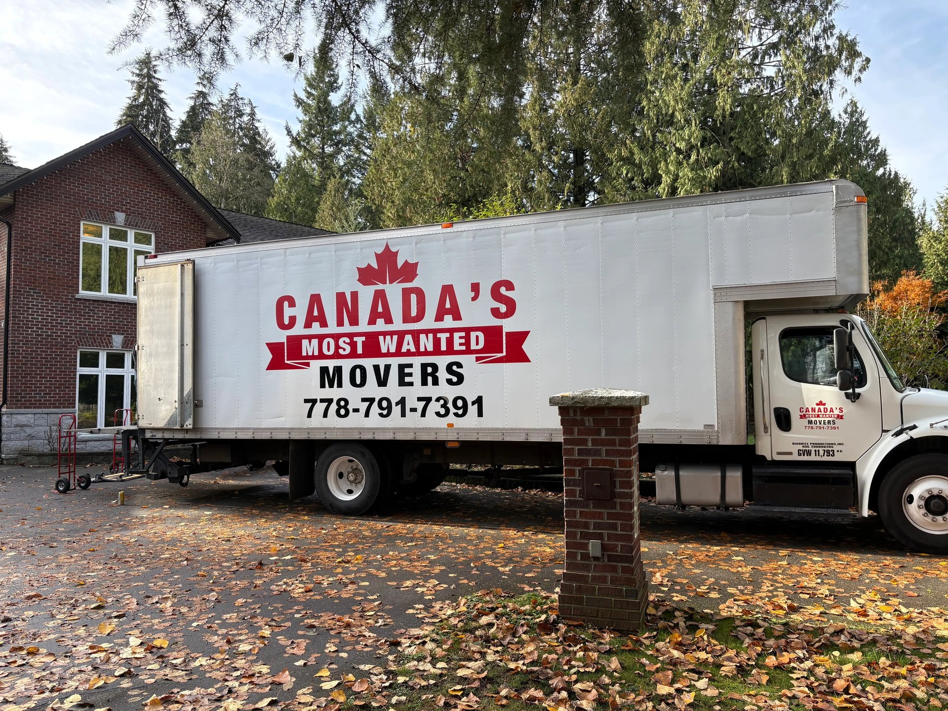 Canada’s Most Wanted Movers truck positioned outside a large brick home for a residential move in Langley..