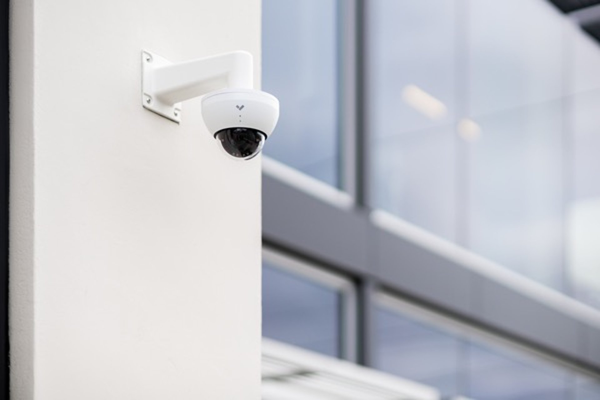 Verkada dome surveillance camera mounted on exterior building wall, providing AI-powered video monitoring
