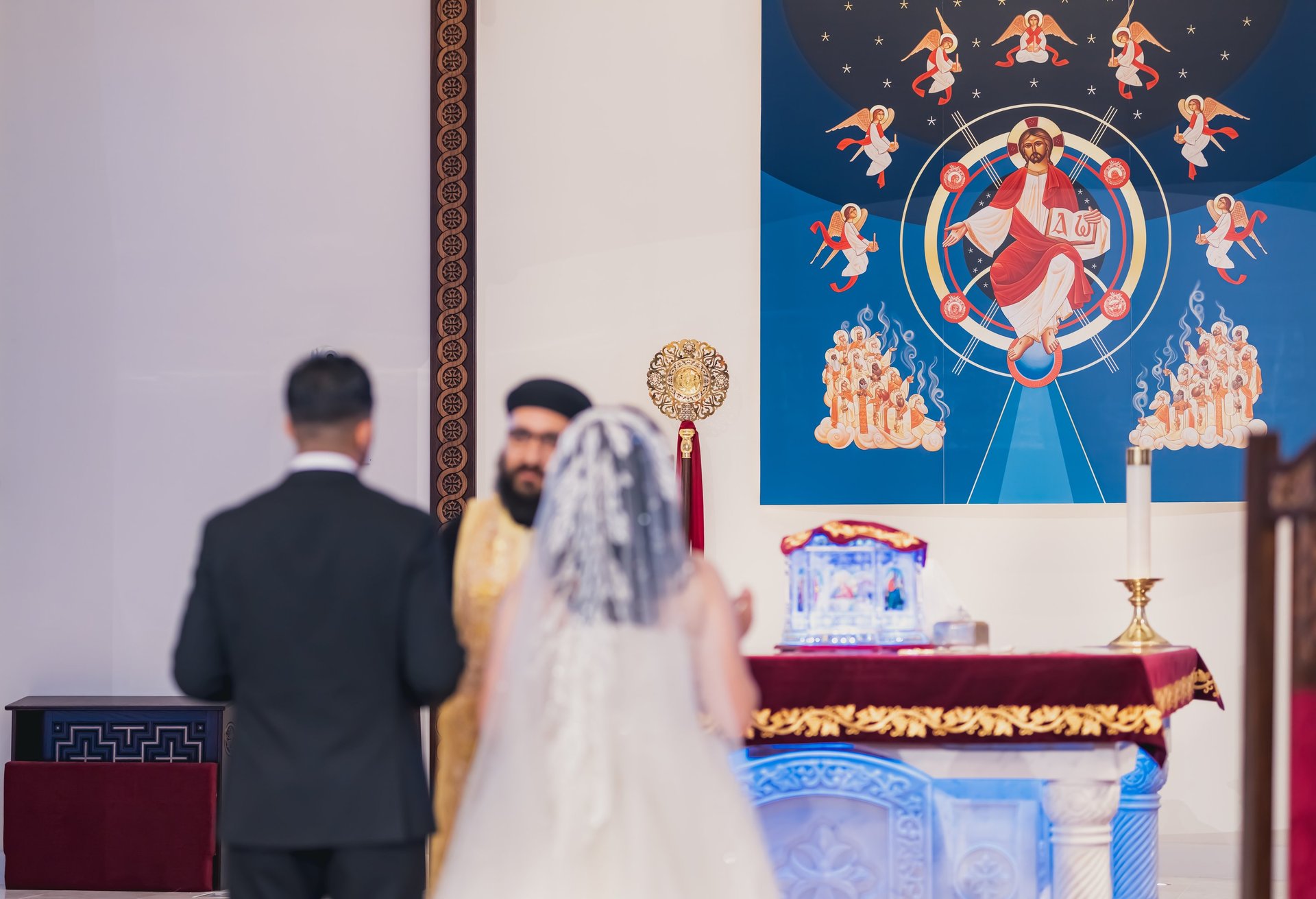 A priest is holding a cup and a cross