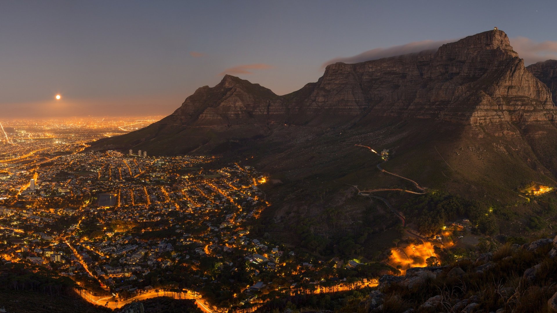 brown rocky mountain beside sea during daytime