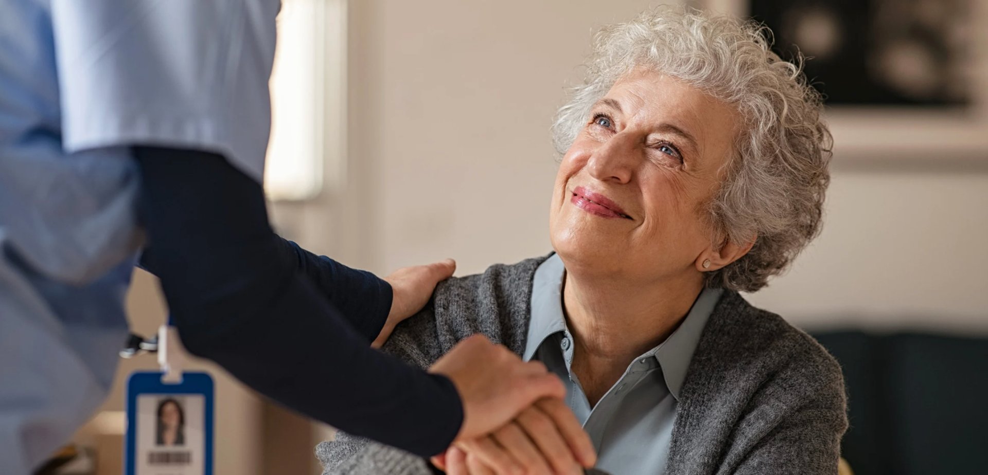 two people sitting on pavement facing on body of water