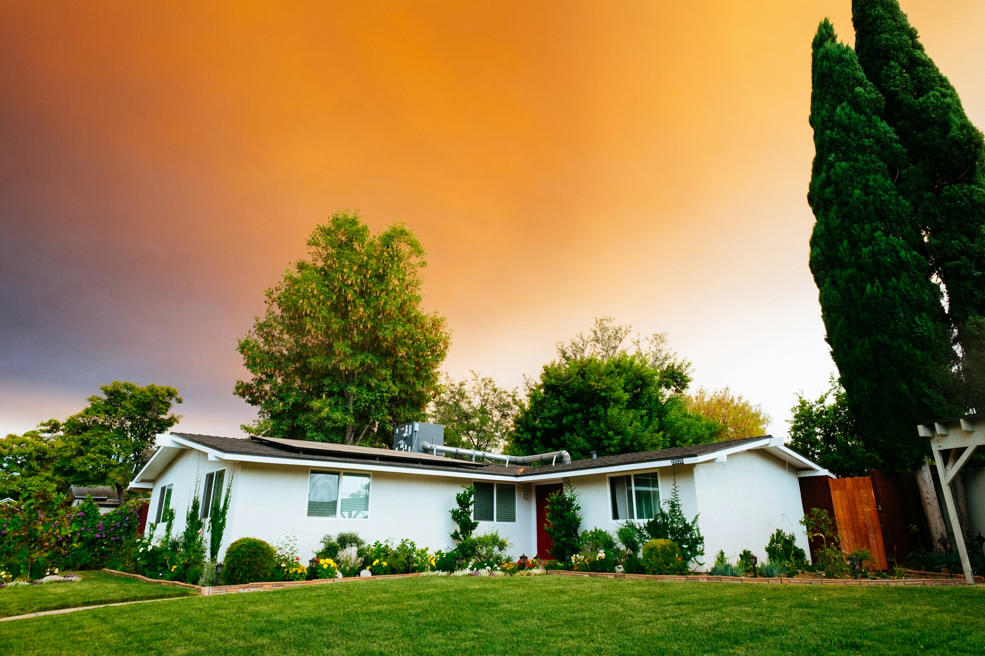white and brown wooden house near green trees during daytime