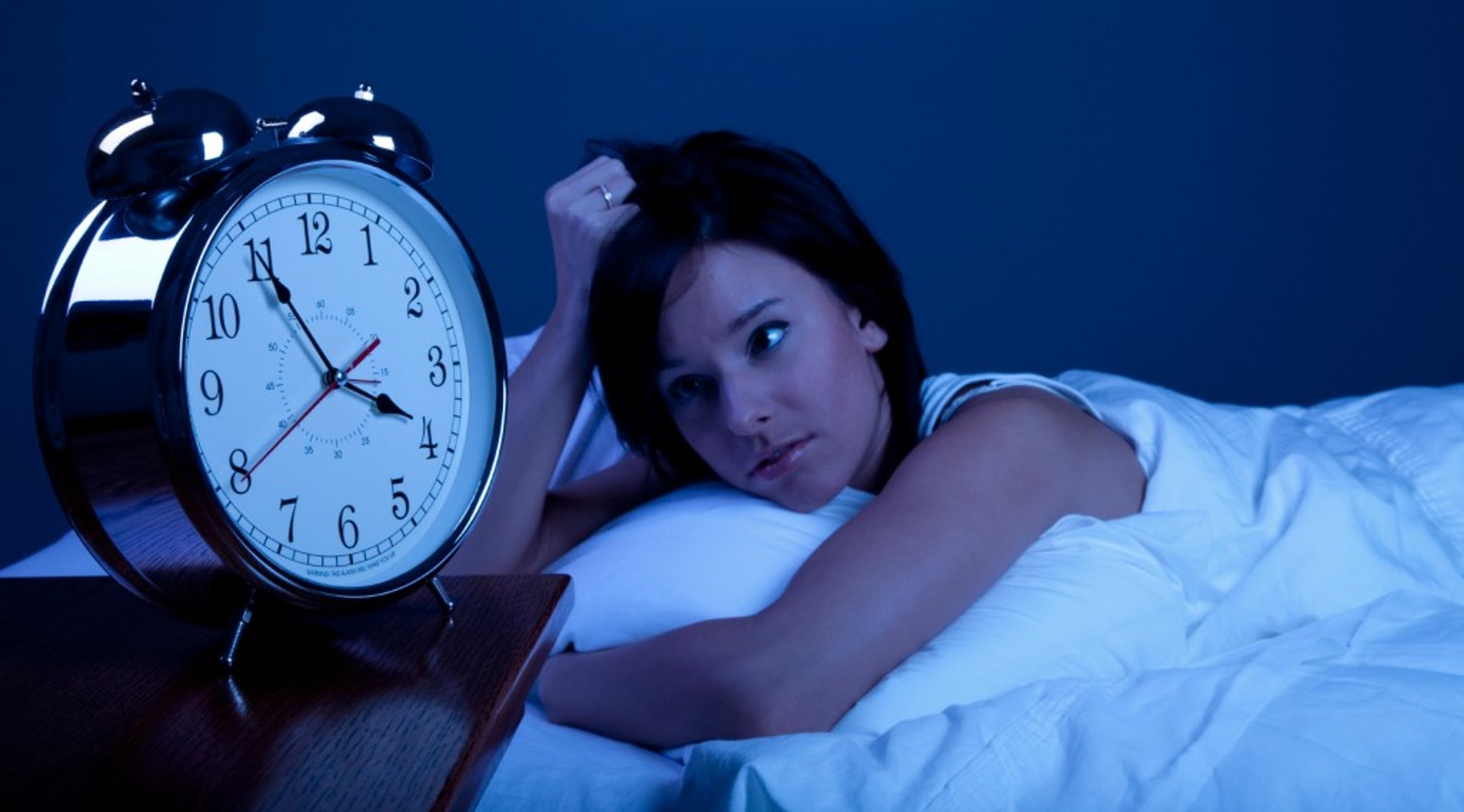 person holding white mini bell alarmclock