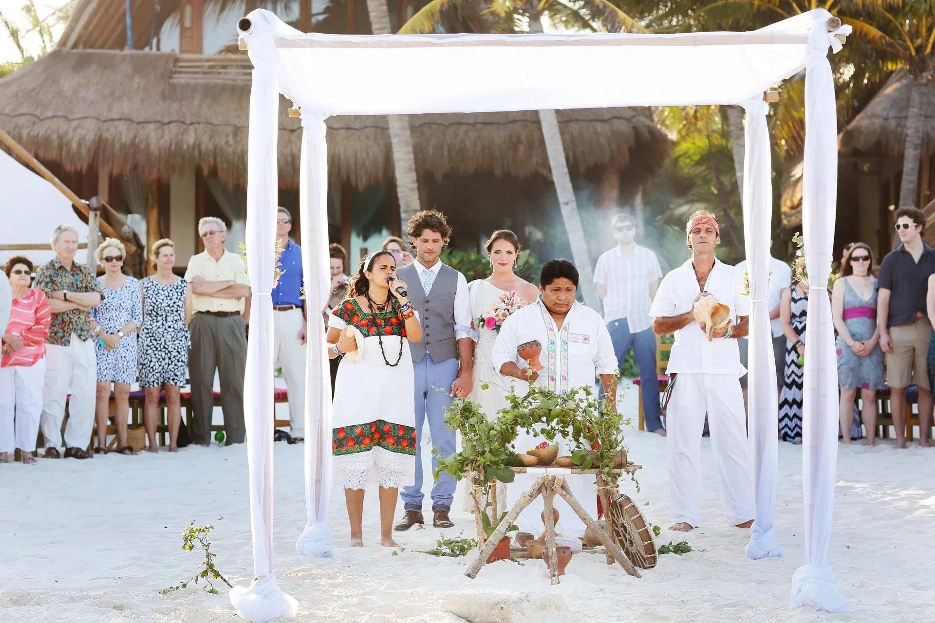 Una pareja participa en una ceremonia de boda maya tradicional en una playa de arena blanca en la riviera maya 